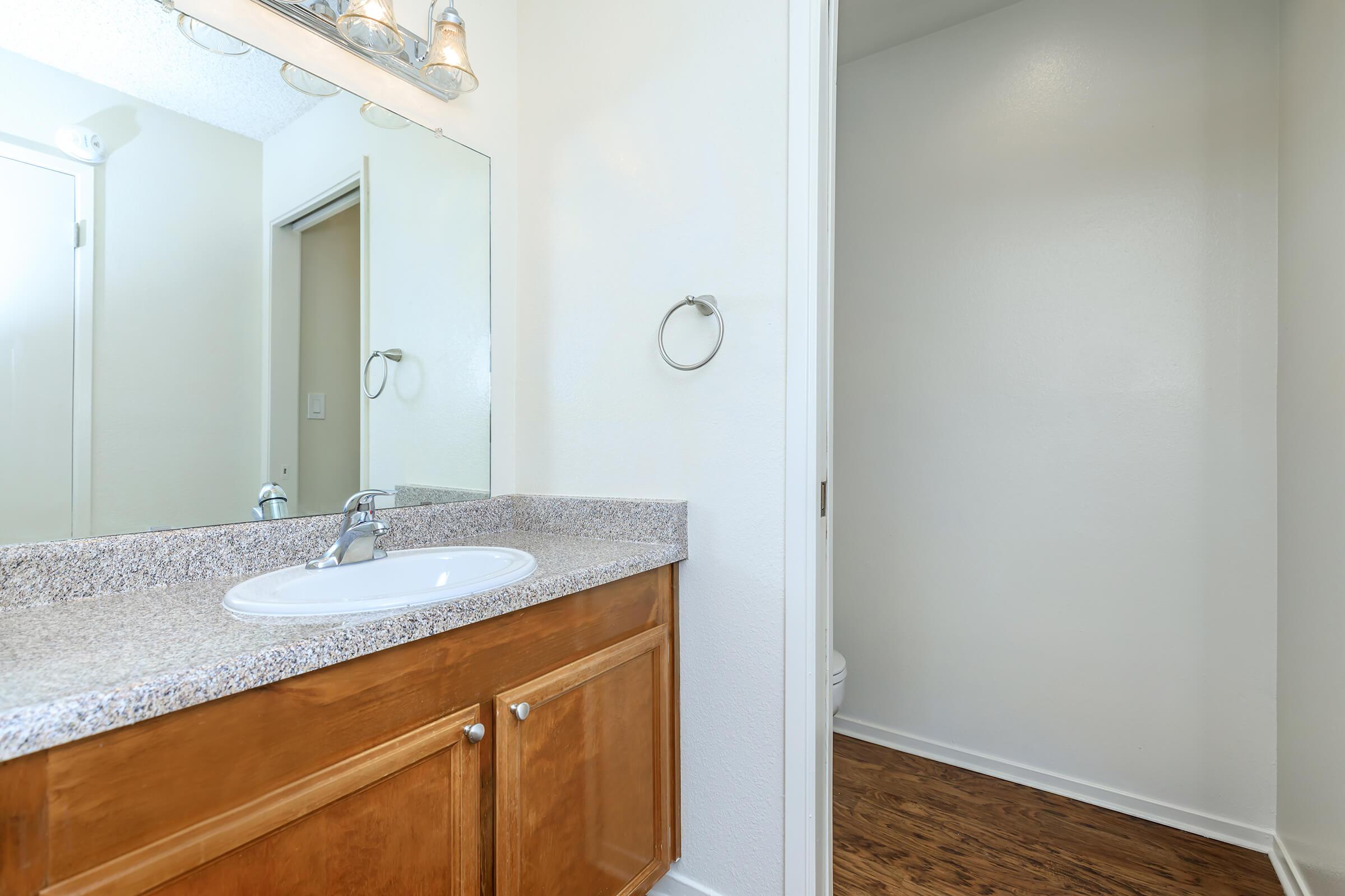 a bedroom area with a sink and a mirror