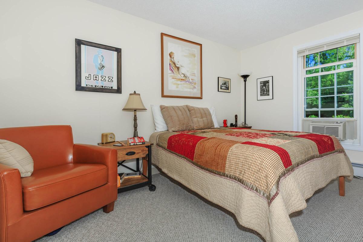 a hotel room with a bed and a couch in a living room