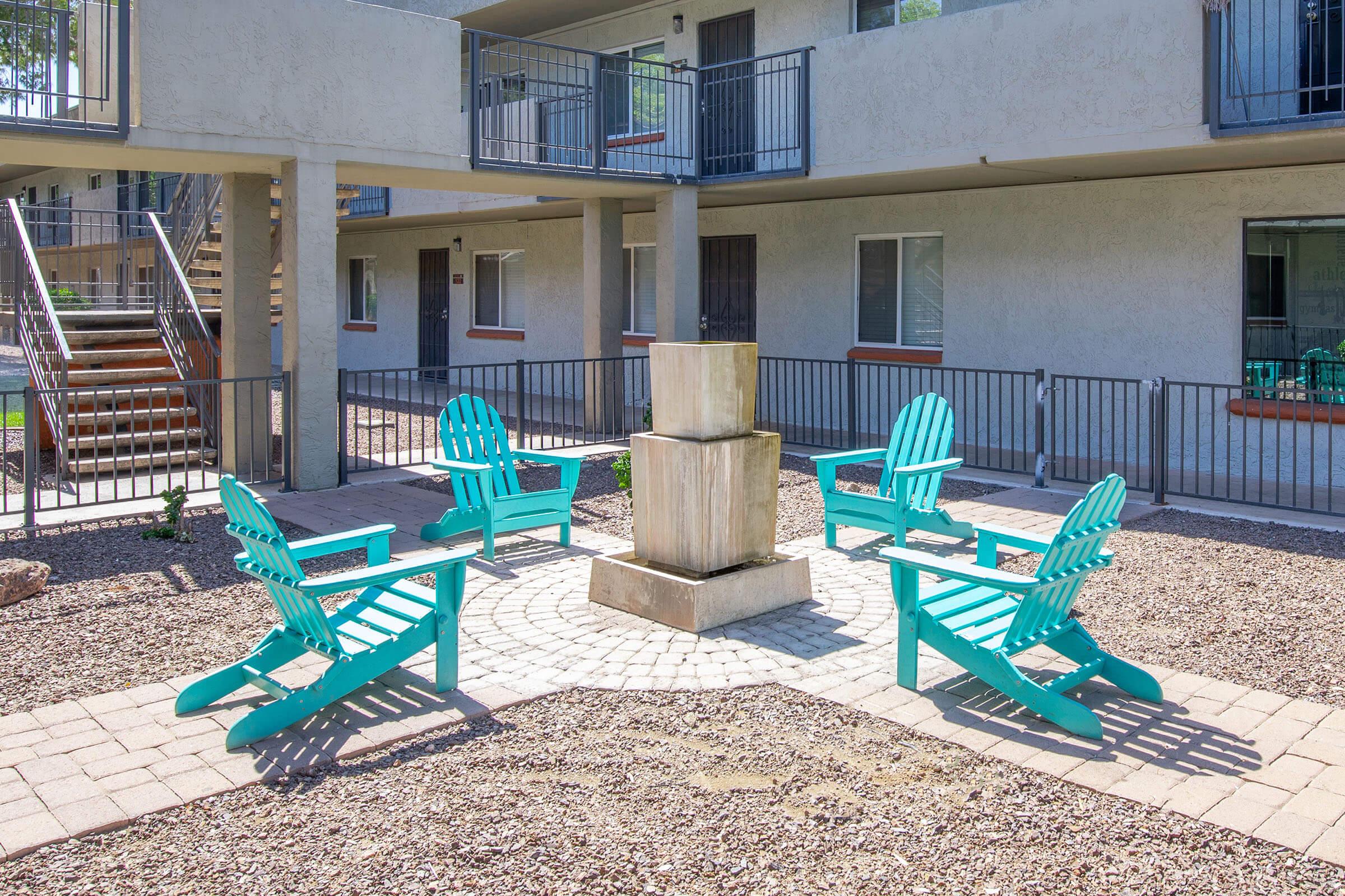 a group of lawn chairs sitting on a bench in front of a building