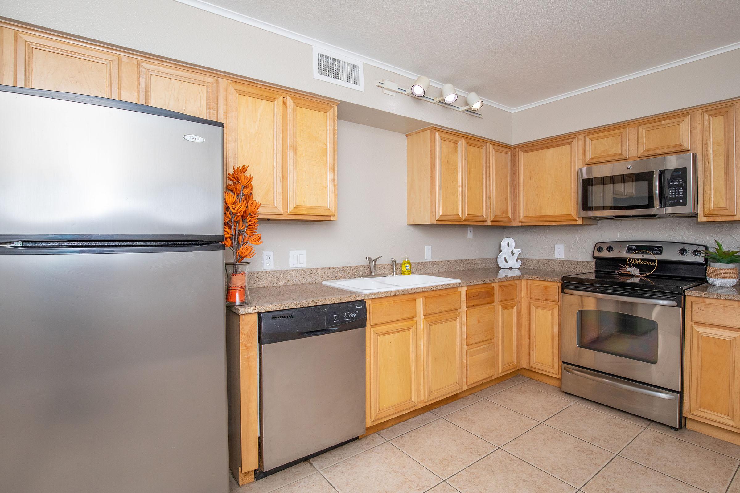 a large kitchen with stainless steel appliances and wooden cabinets