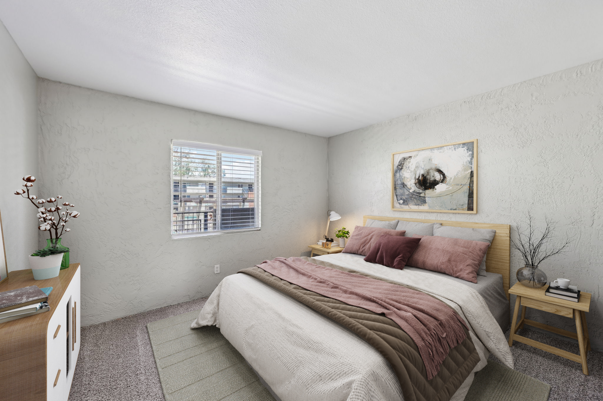 A cozy bedroom featuring a bed with pink and neutral bedding, accent pillows, and a light wooden headboard. A nightstand with a lamp, a plant, and decorative items are present. The walls are light gray, and a window allows natural light to filter in, showcasing a view of the outdoors.