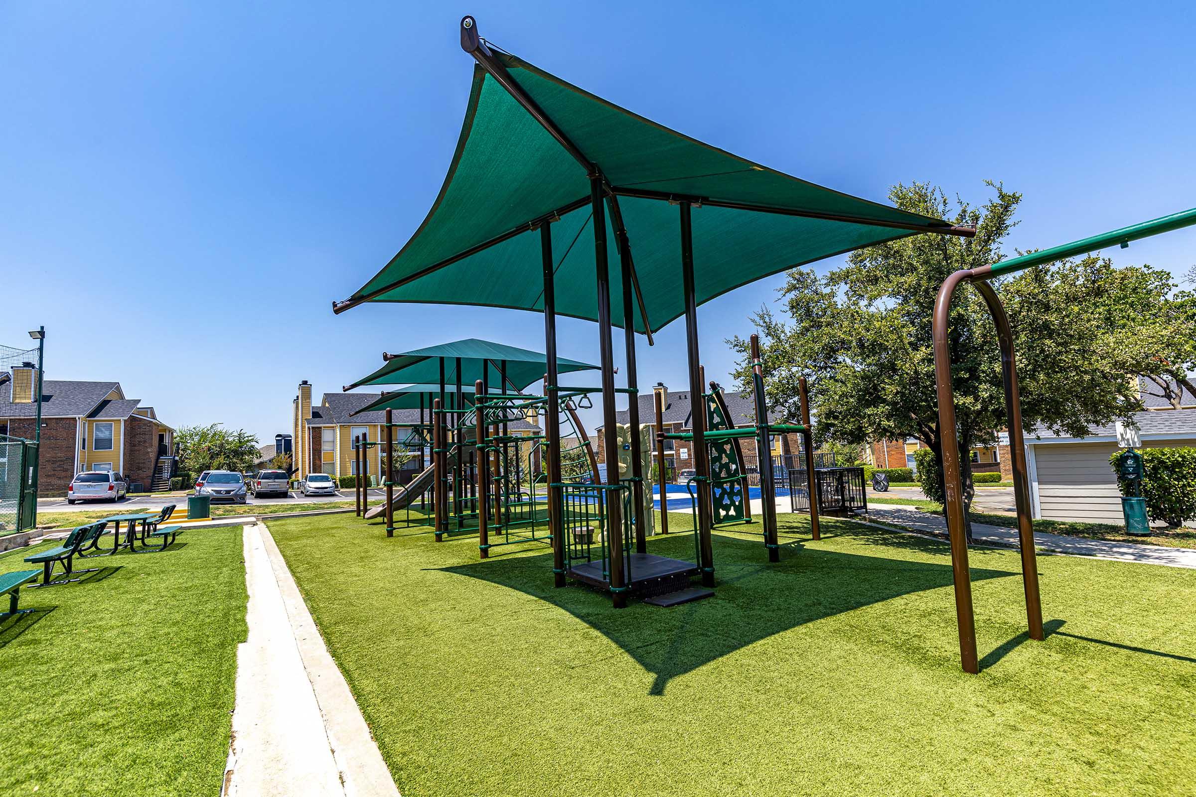 a group of lawn chairs sitting on top of a green umbrella