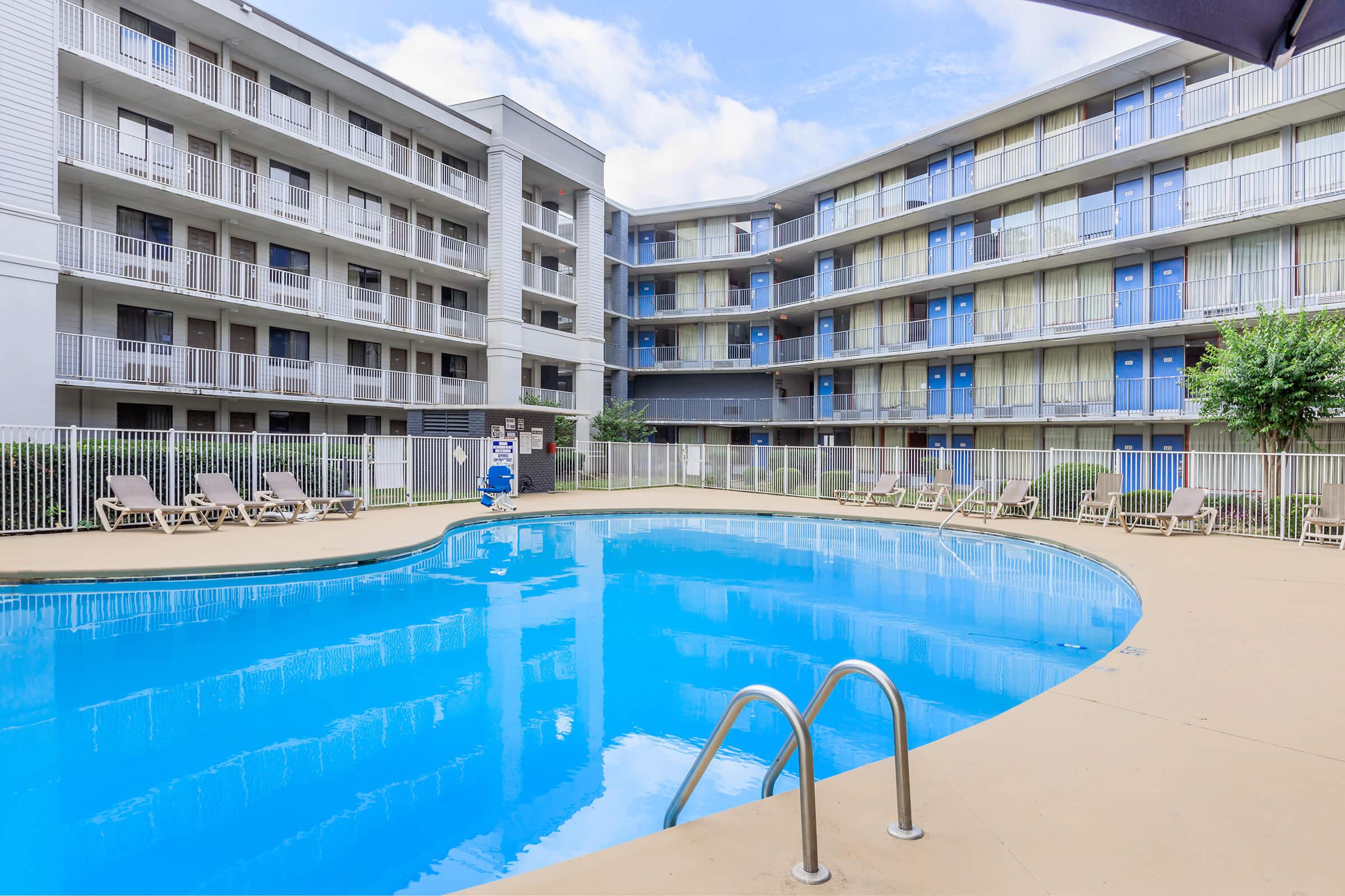 a blue pool of water in front of a building