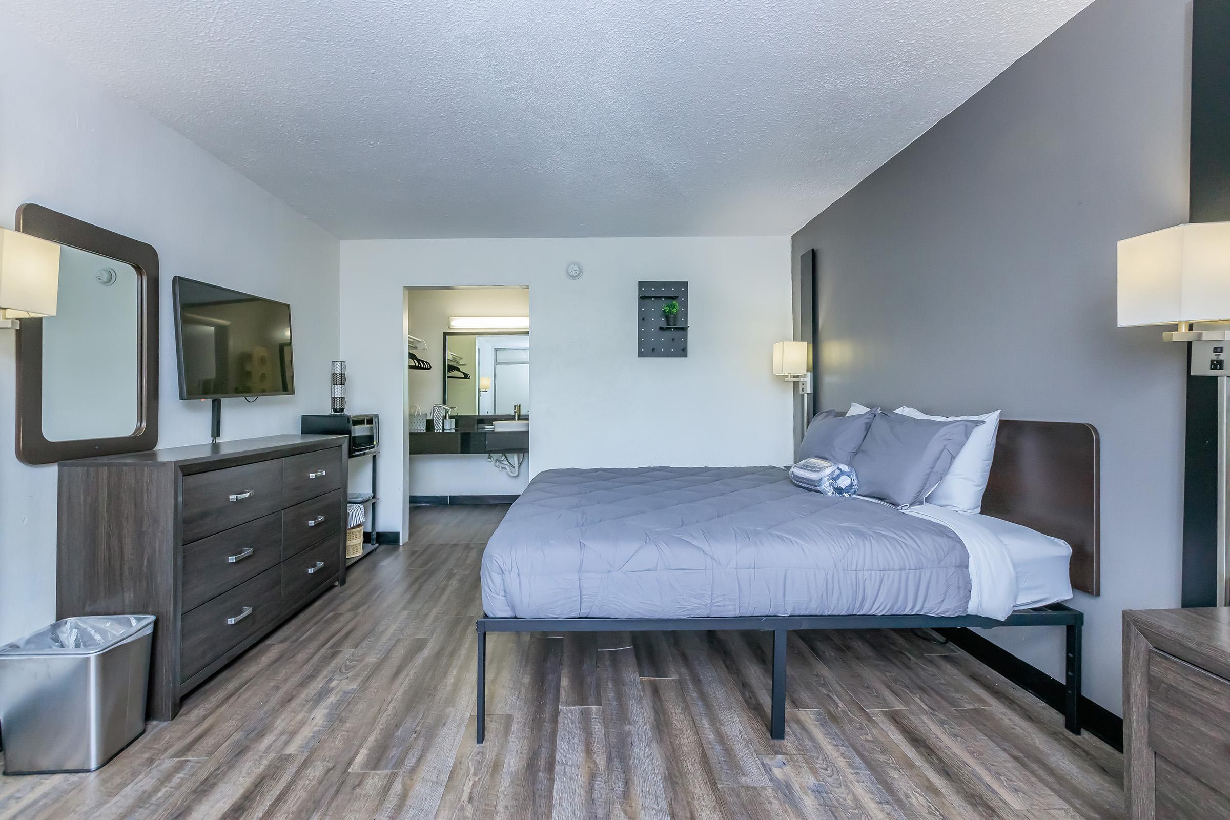 a bedroom with a bed and desk in a room