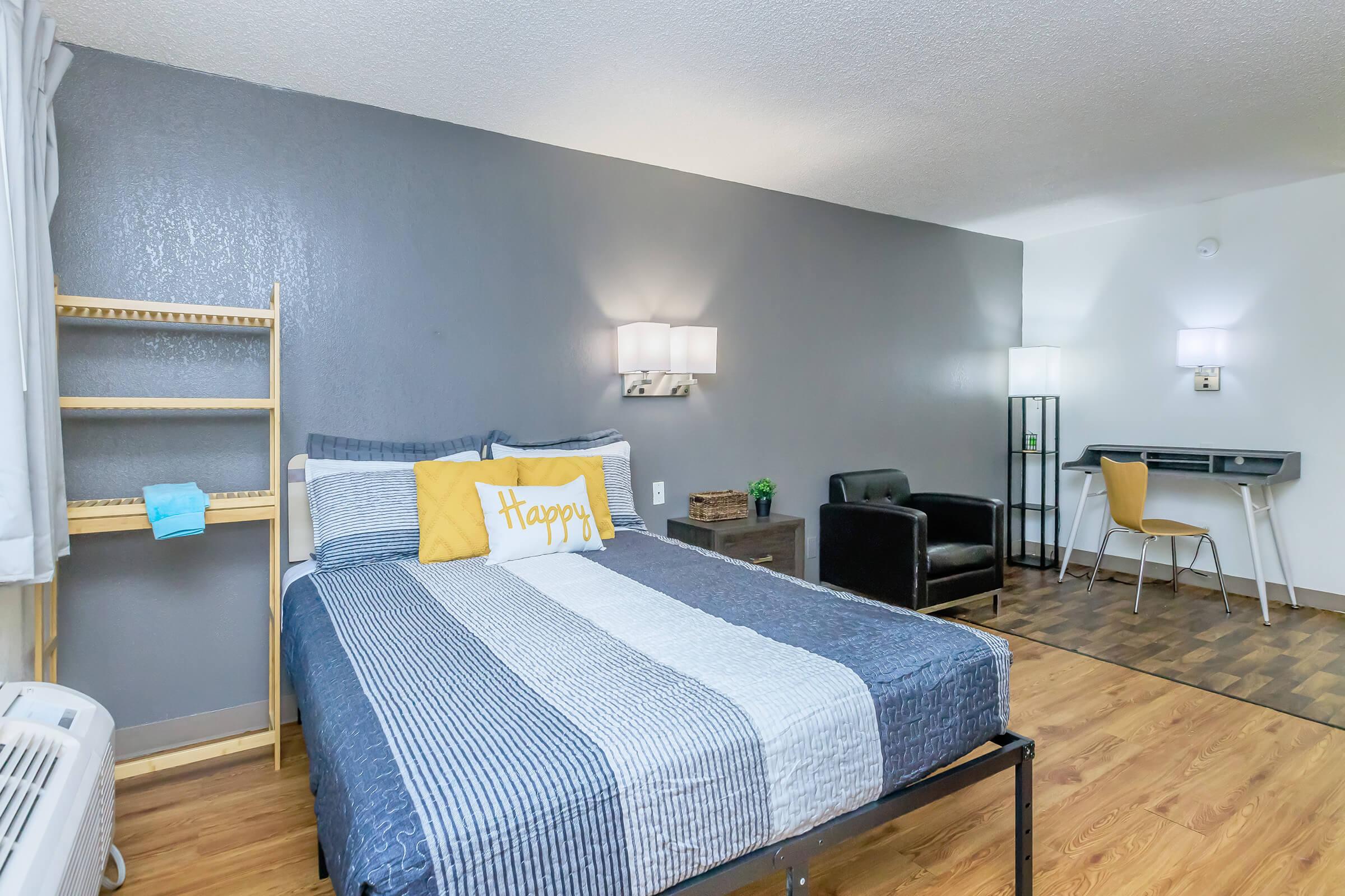 a bedroom with a bed and desk in a room