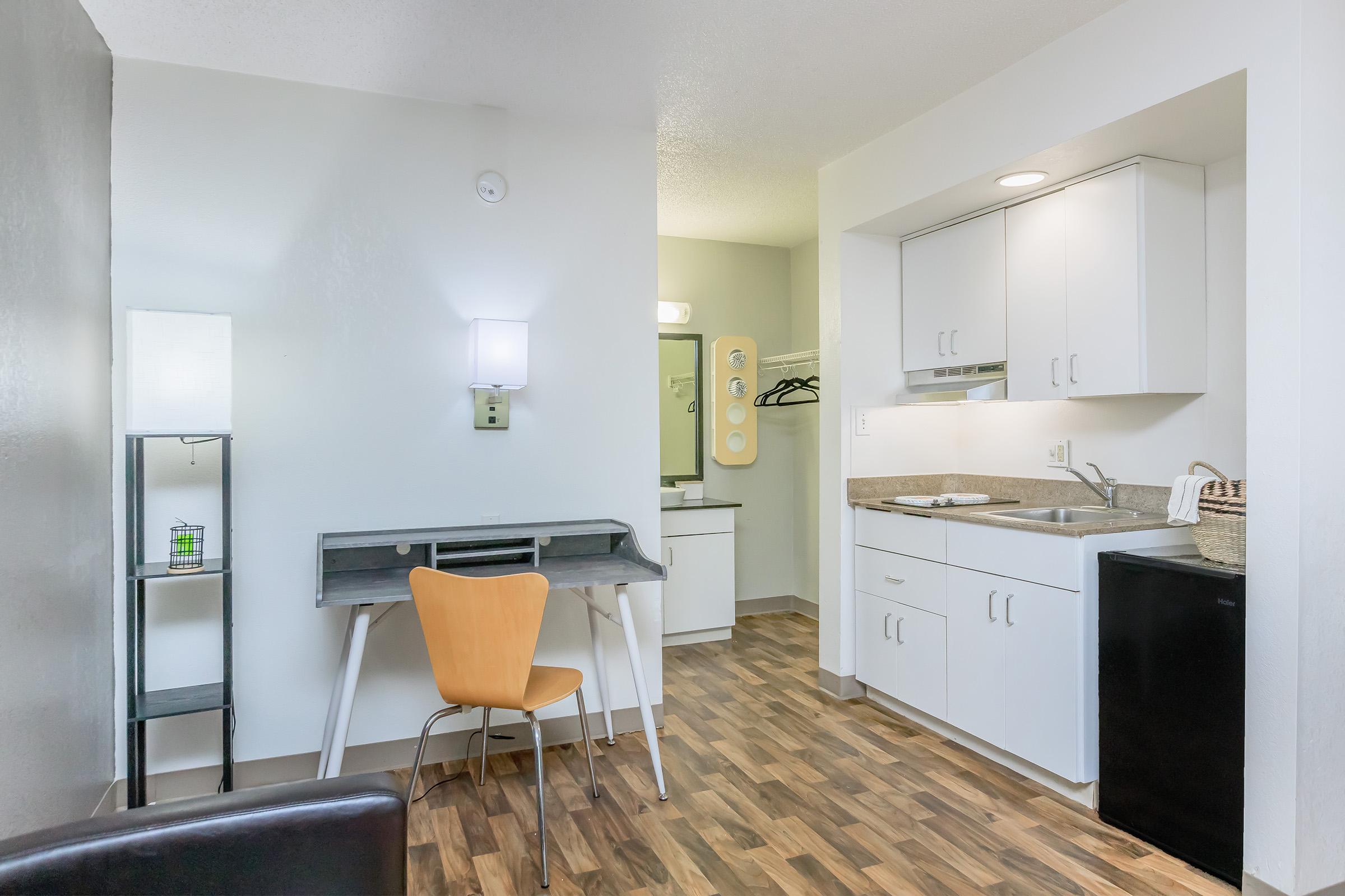 a kitchen with a sink and a mirror in a room