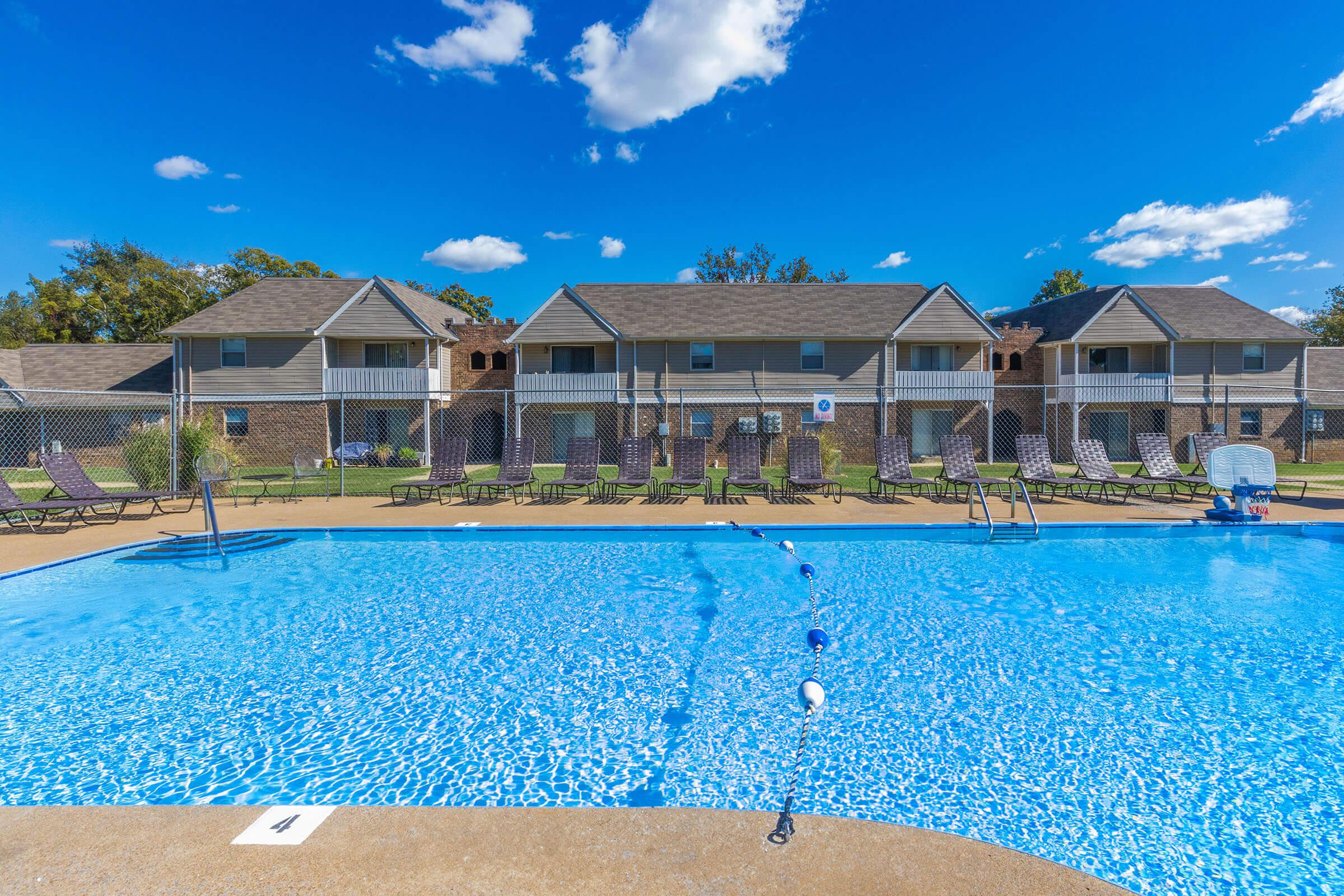 a group of lawn chairs sitting on top of a blue pool of water