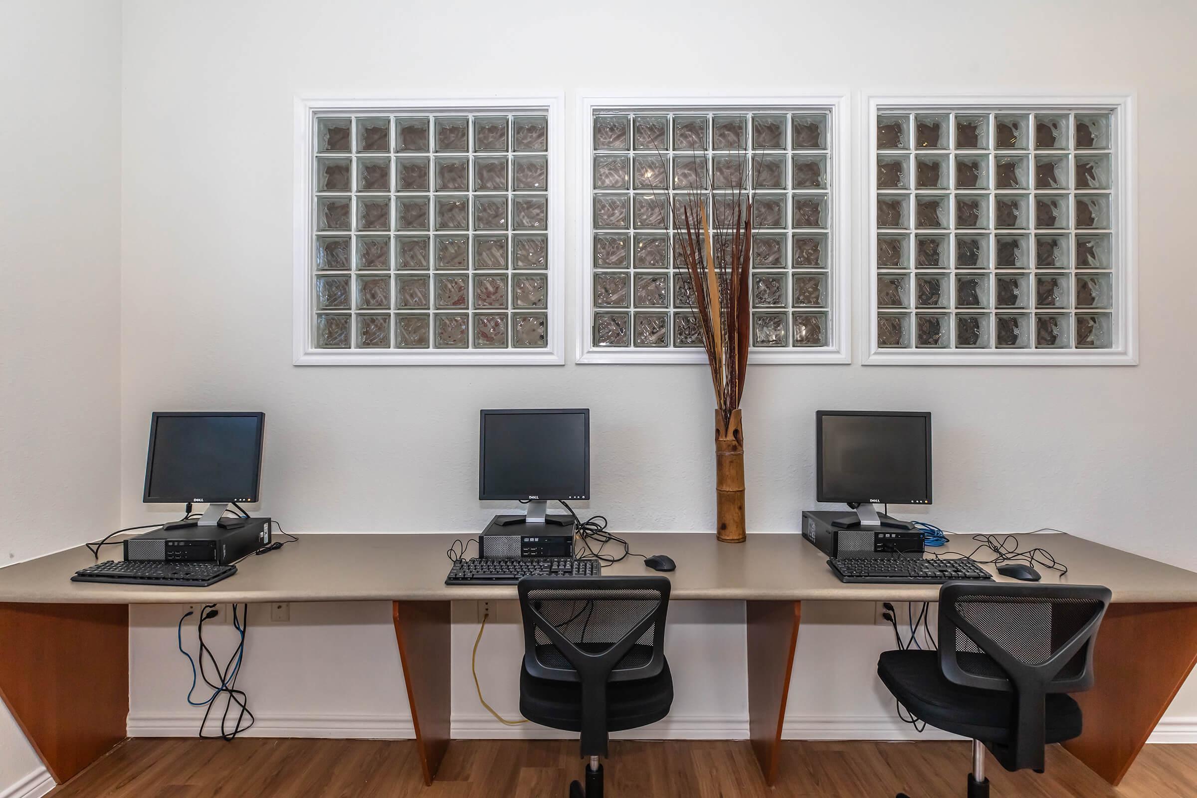 a desk with a computer and a chair in a room