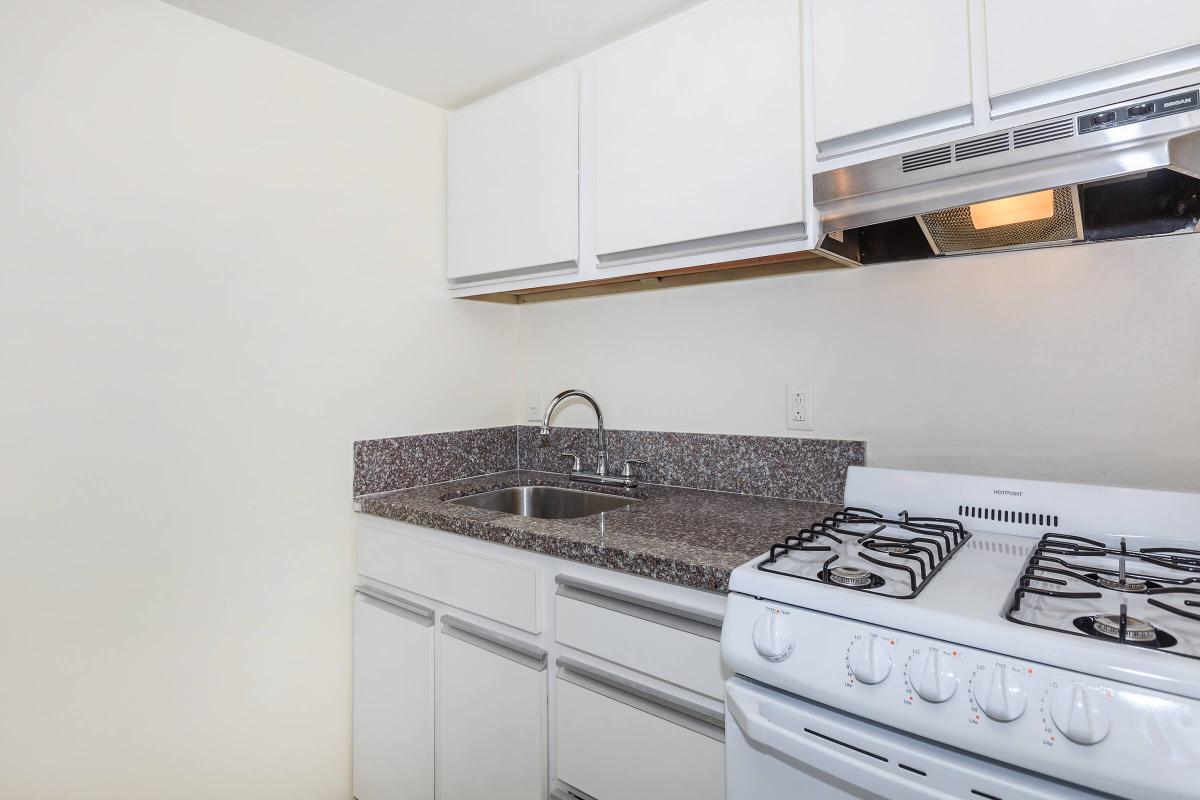 a stove top oven sitting inside of a kitchen