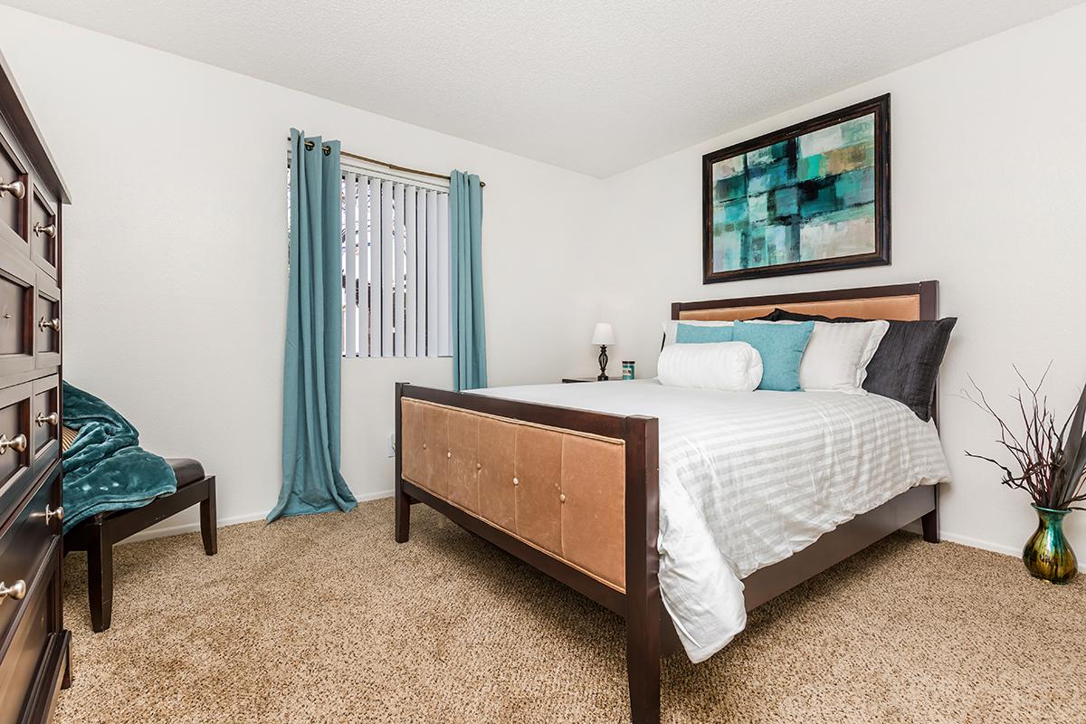 a bedroom with a bed and desk in a room