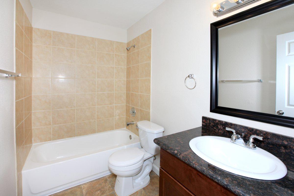 a white sink sitting under a mirror