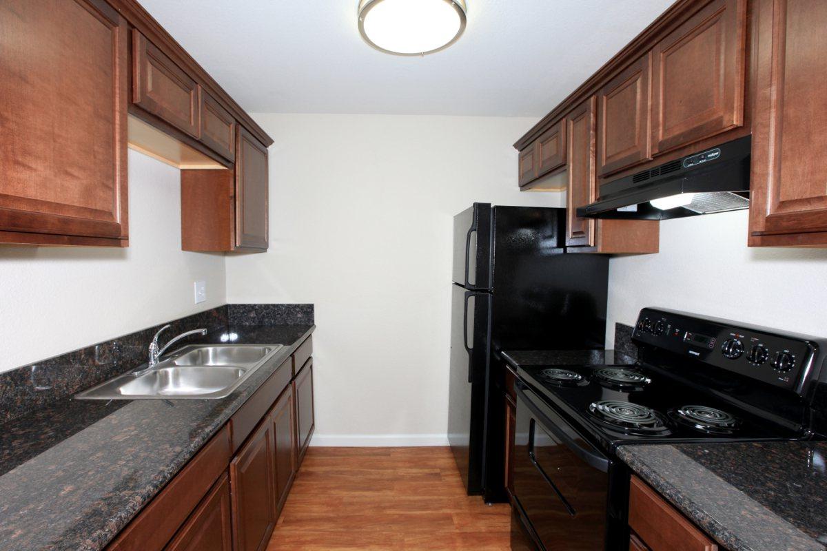 a modern kitchen with stainless steel appliances and wooden cabinets