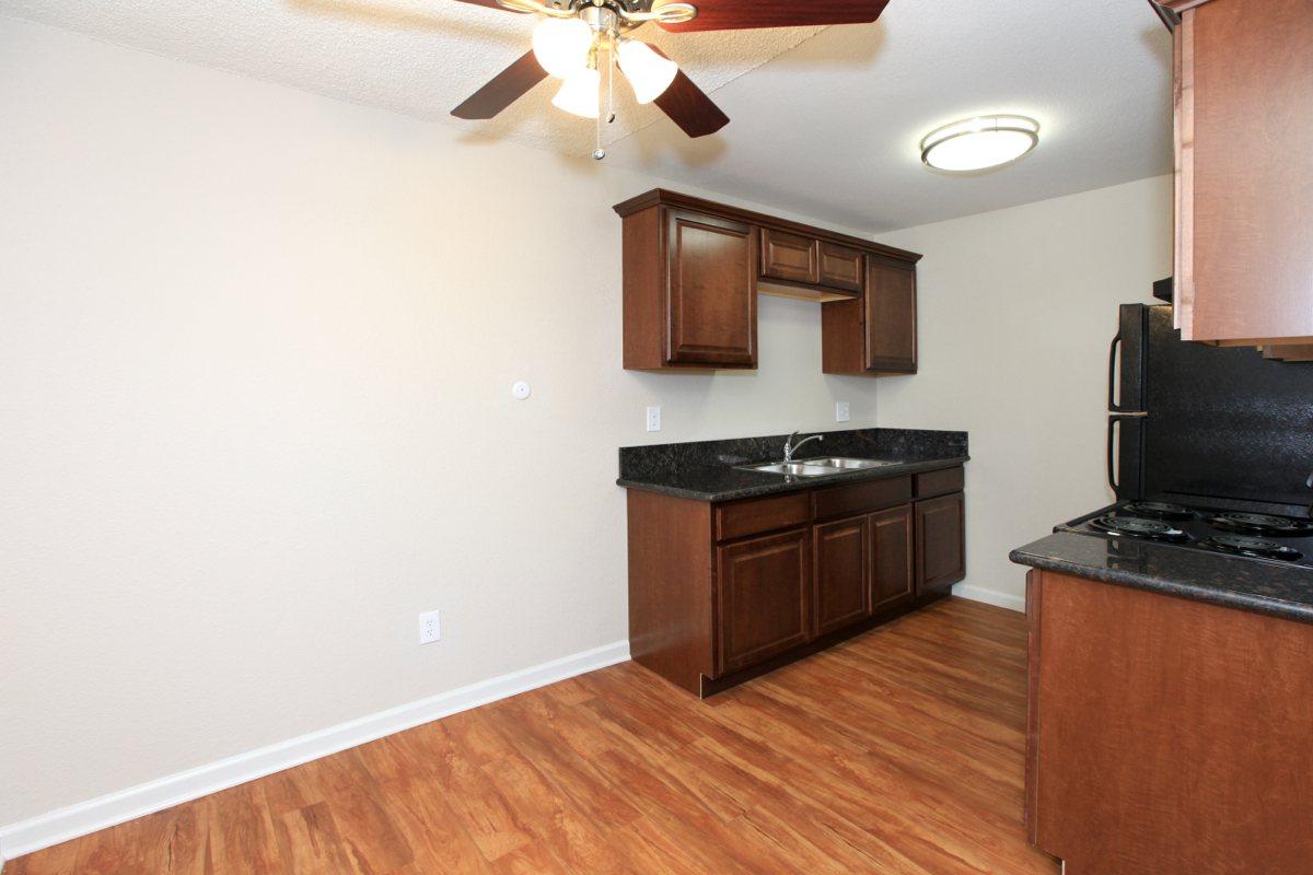 a large kitchen with stainless steel appliances and wooden cabinets