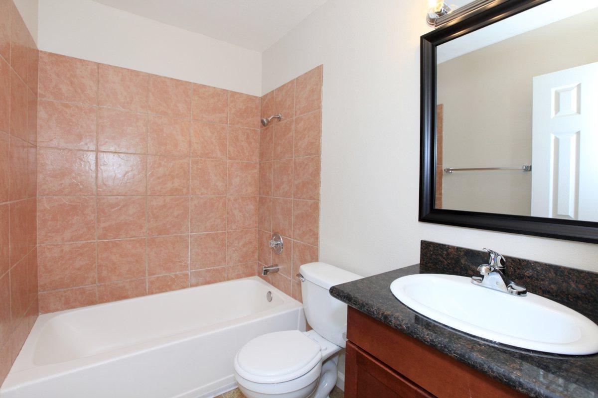 a white sink sitting under a mirror