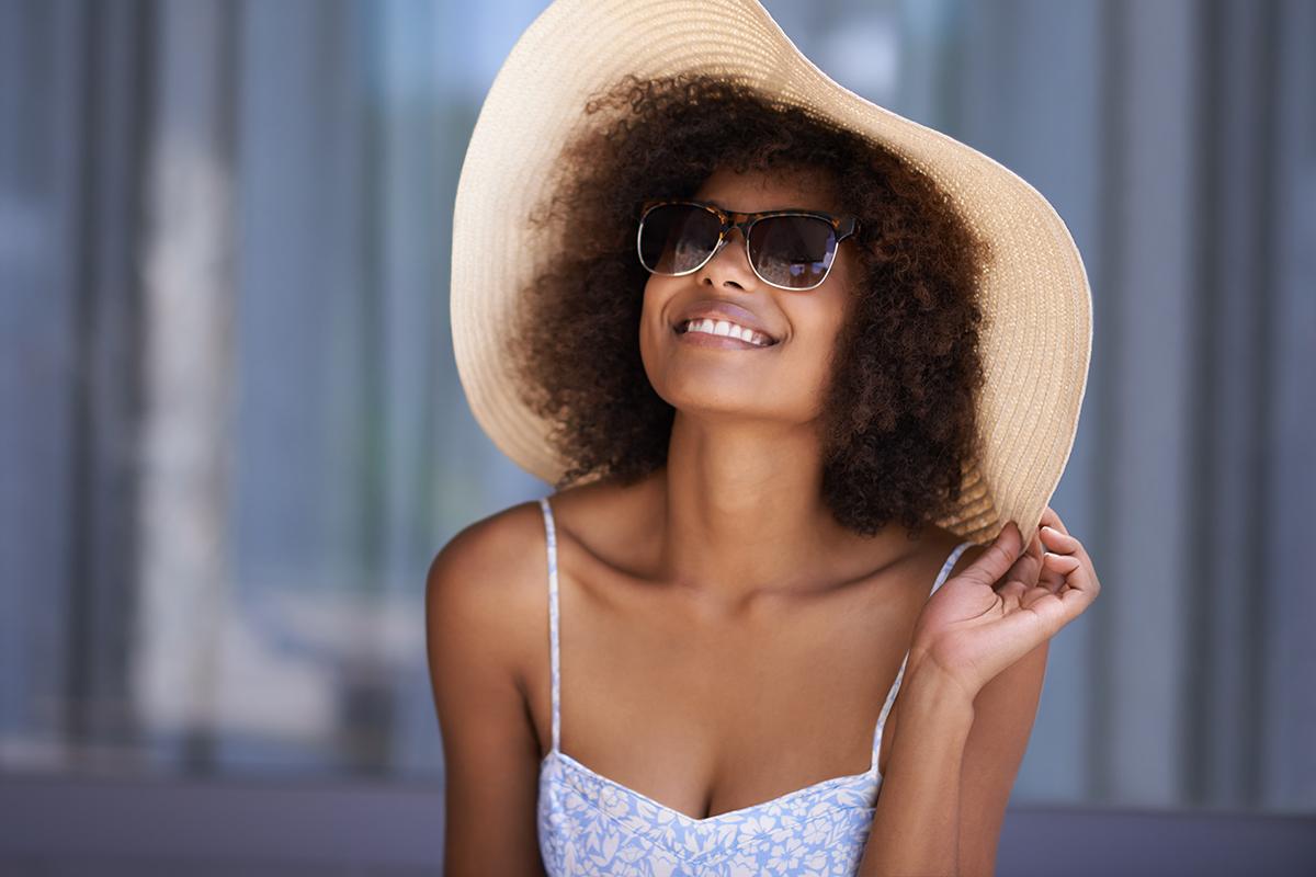 a person wearing a hat and sunglasses posing for the camera
