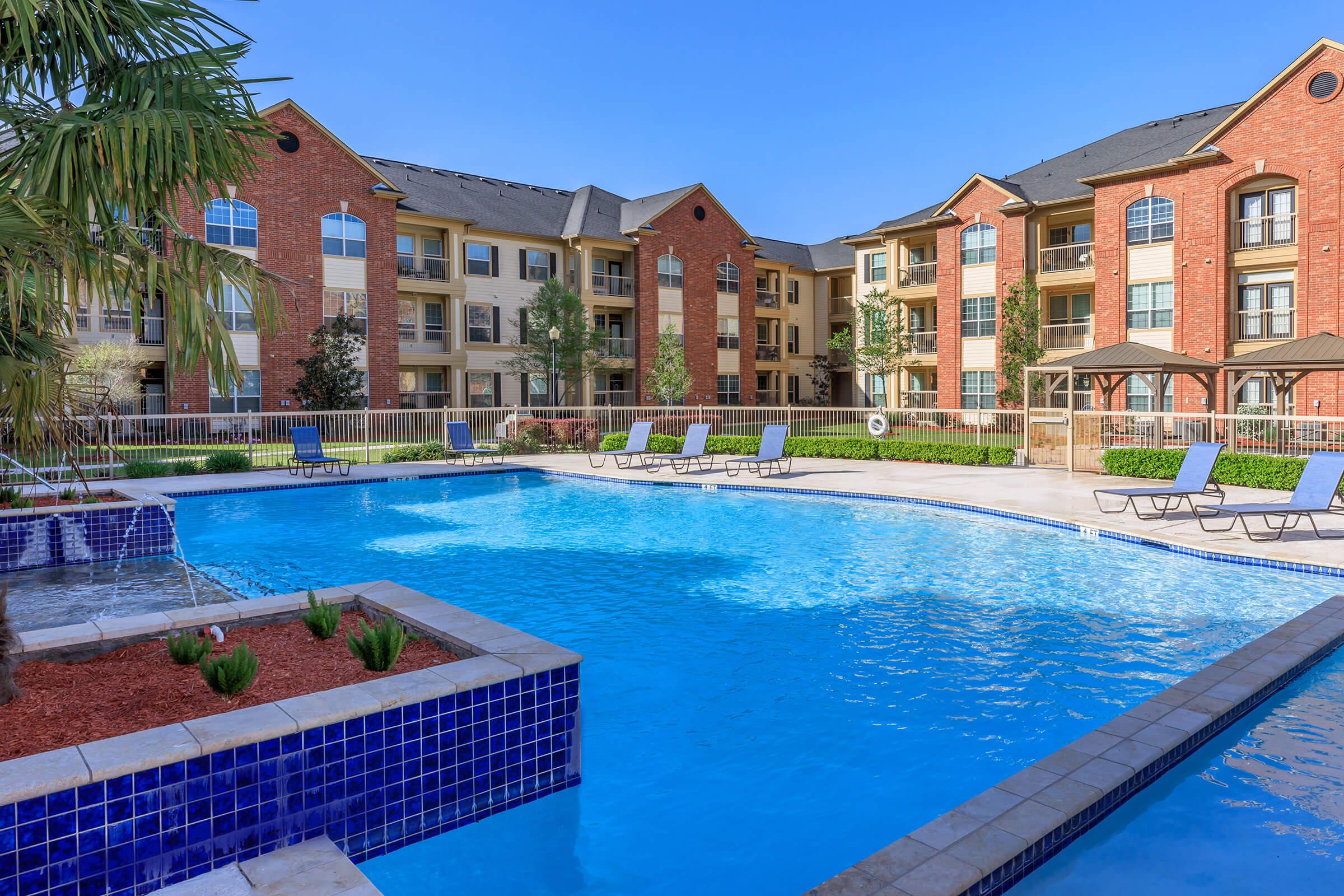 a large brick building with a pool of water