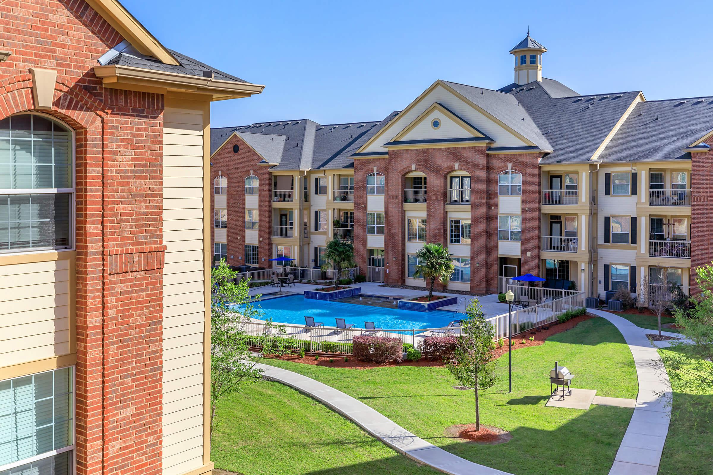 a large lawn in front of a brick building