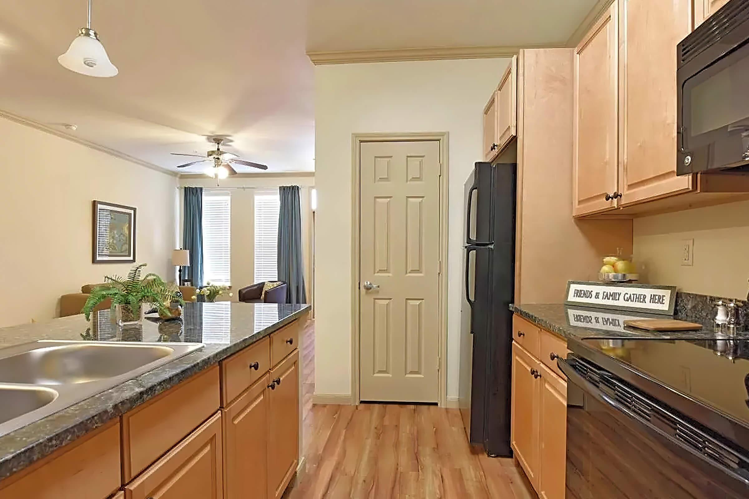 a large kitchen with stainless steel appliances and wooden cabinets