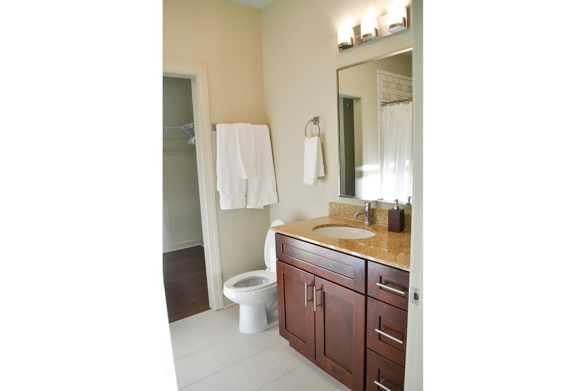a white sink sitting under a mirror