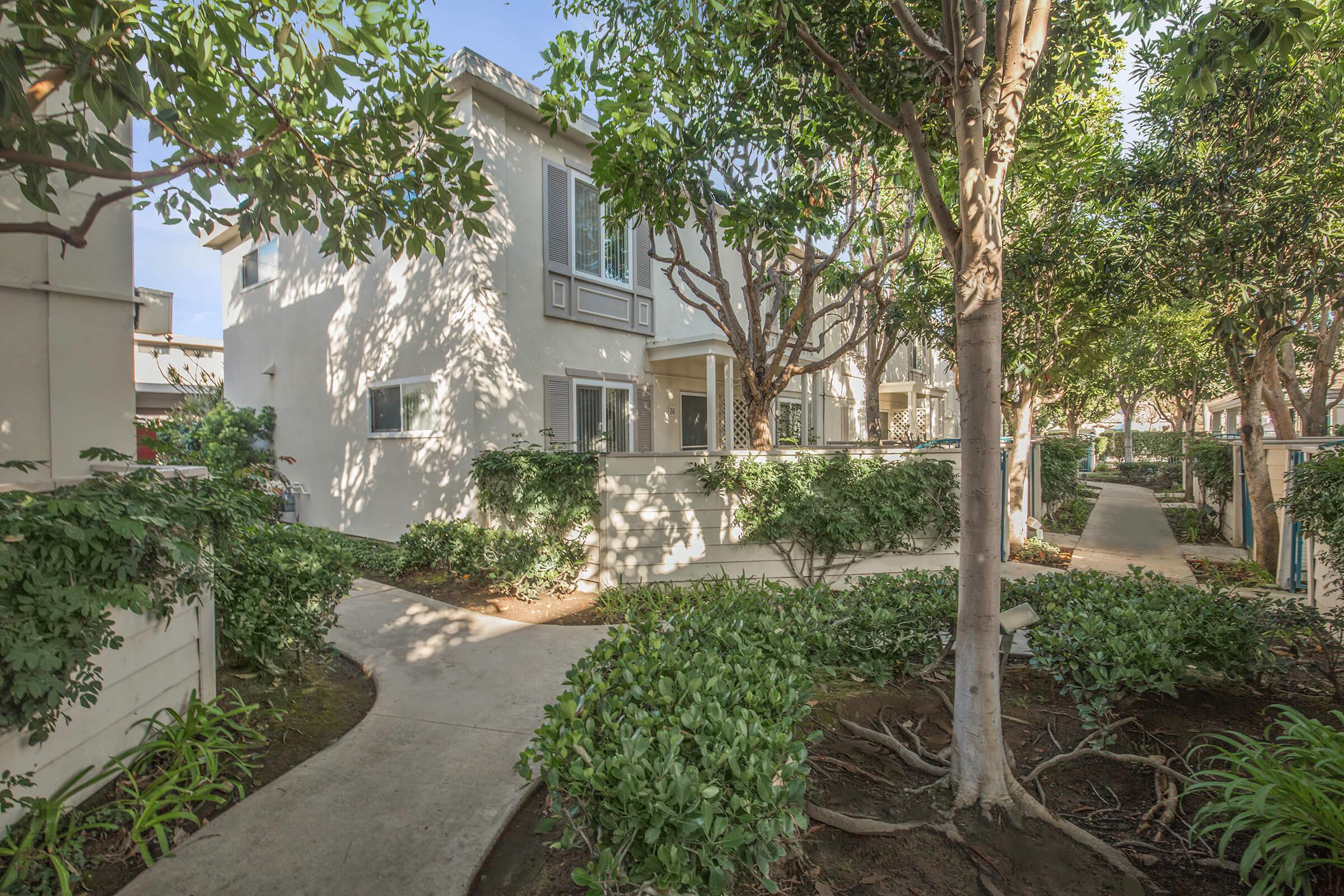 Sandpointe Cove Apartment Homes community building with bushes and trees
