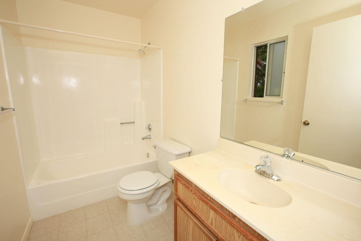 a white sink sitting under a mirror