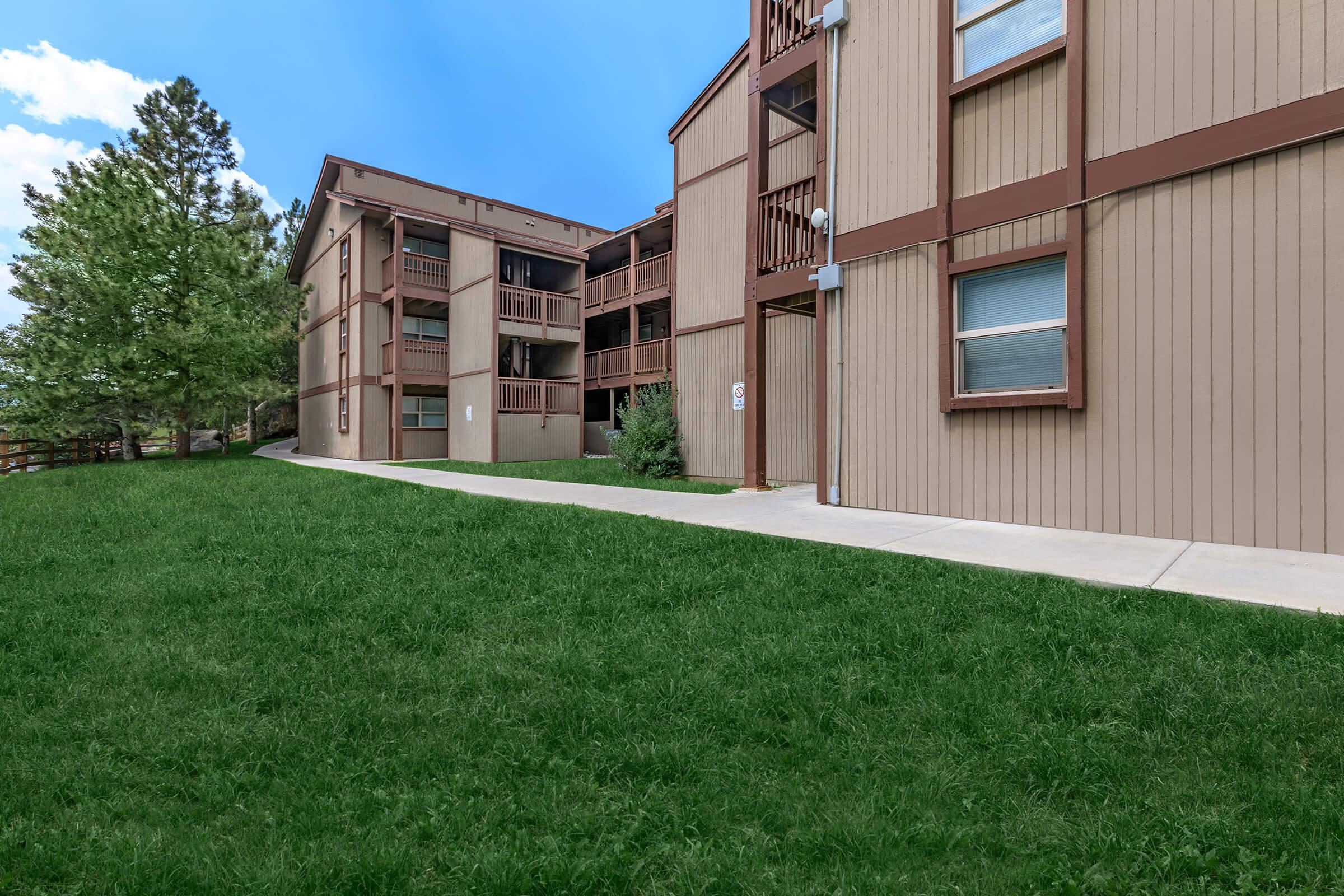 a large lawn in front of a brick building