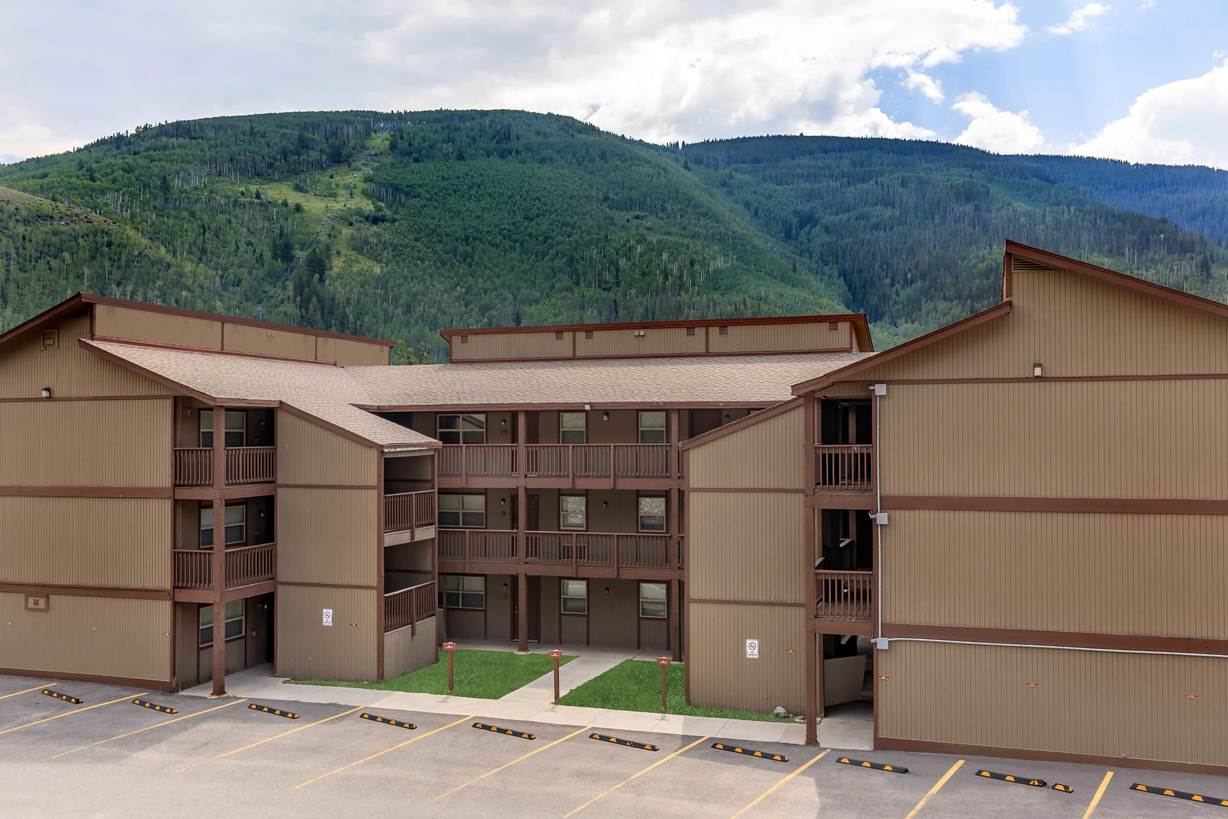 a large brick building with a mountain in the background