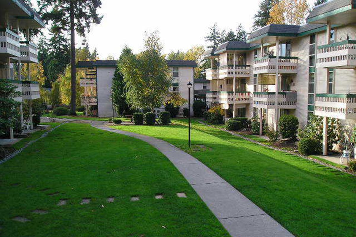 a large brick building with grass in front of a house