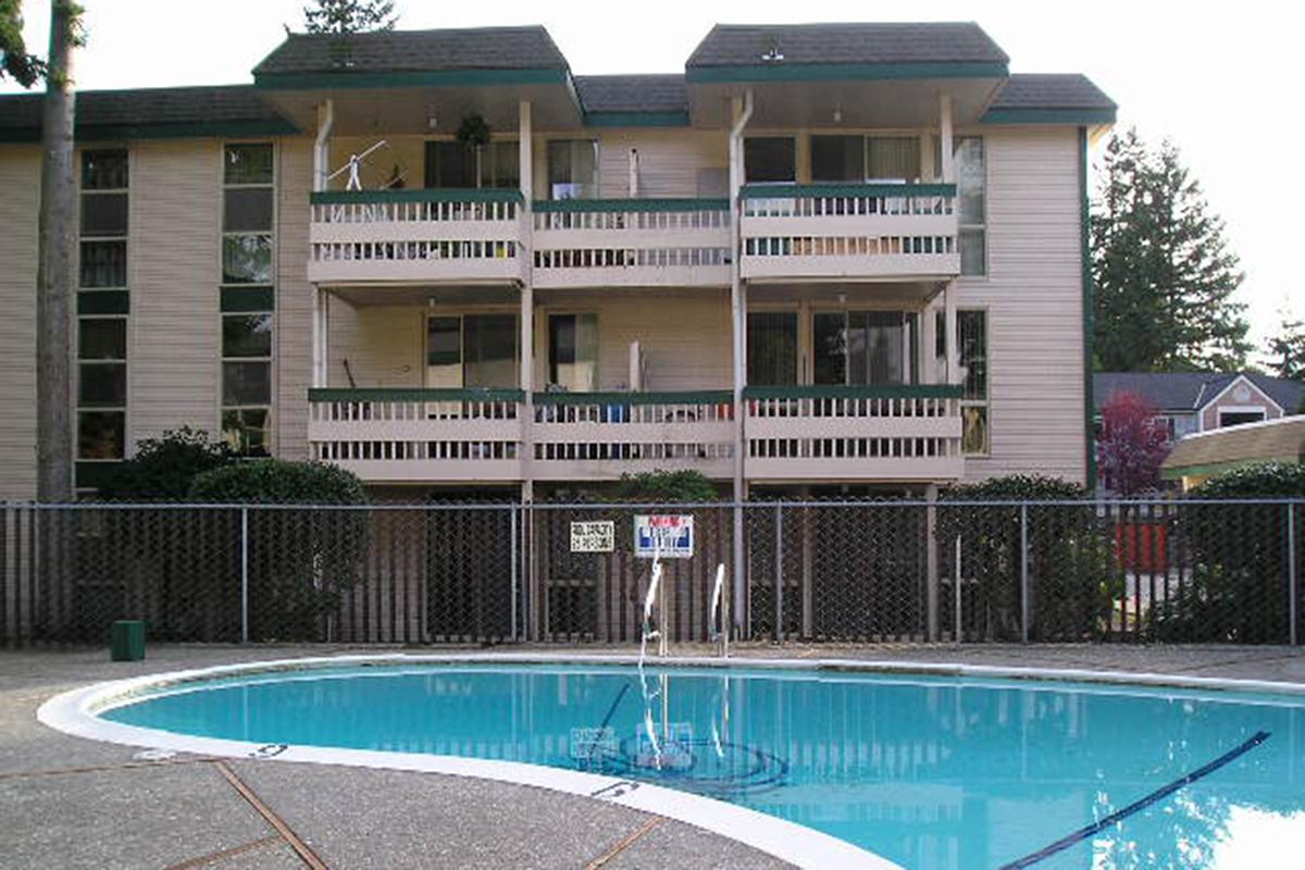 a house with a pool in front of a building