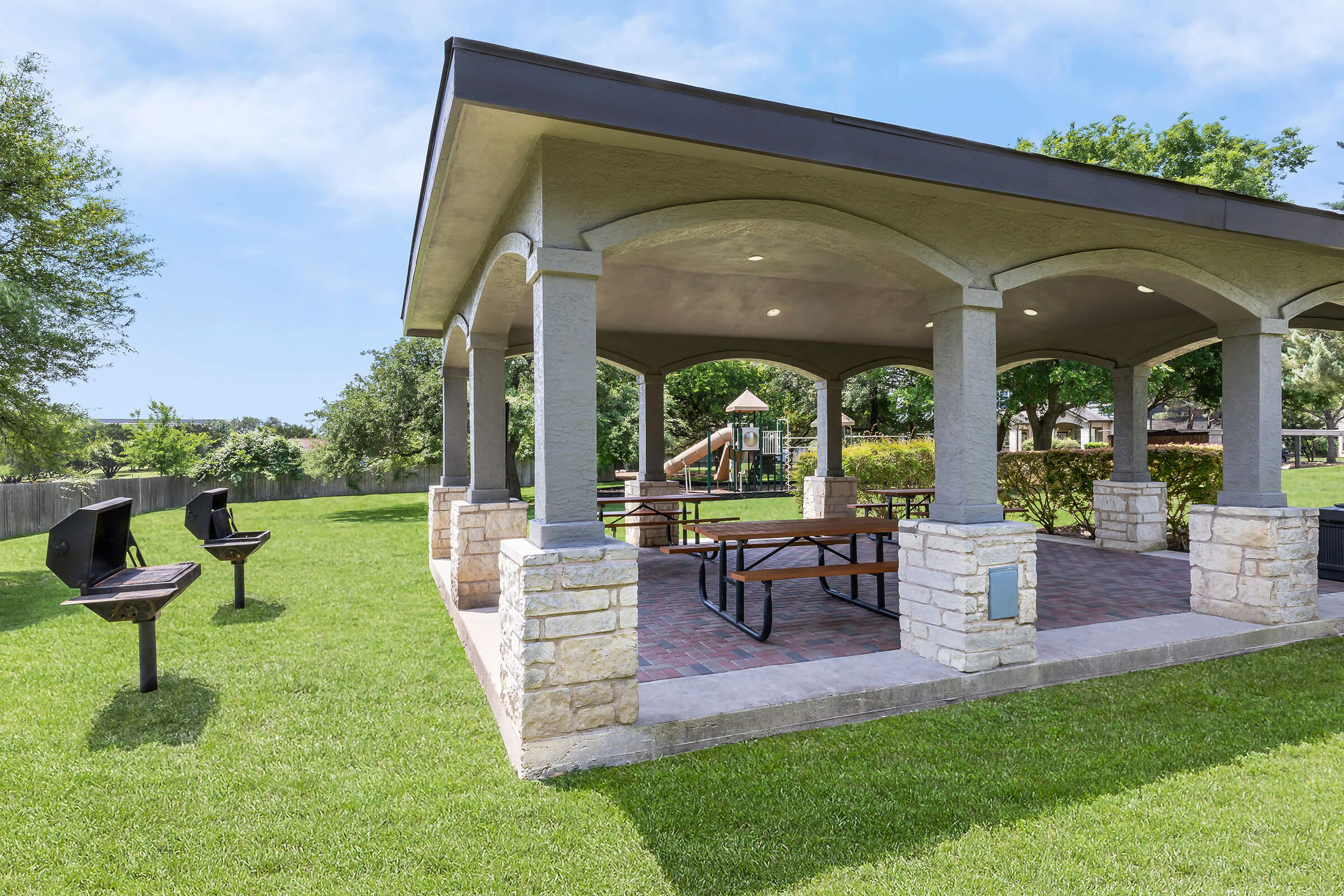 barbecues and picnic tables under a pavilion