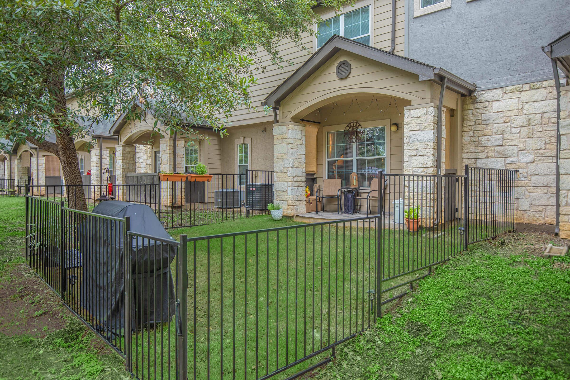 a house with a fence in front of a building