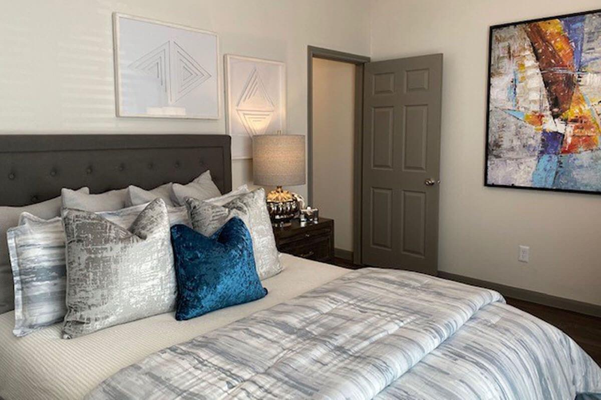 a bedroom with a bed and a painting on the wall