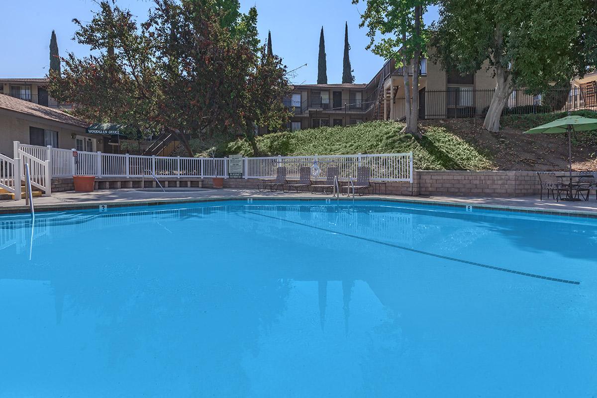 Woodglen Apartment Homes community pool with green grass