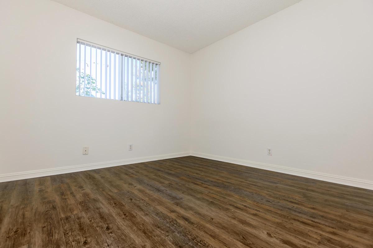 Unfurnished bedroom with wooden floors and window