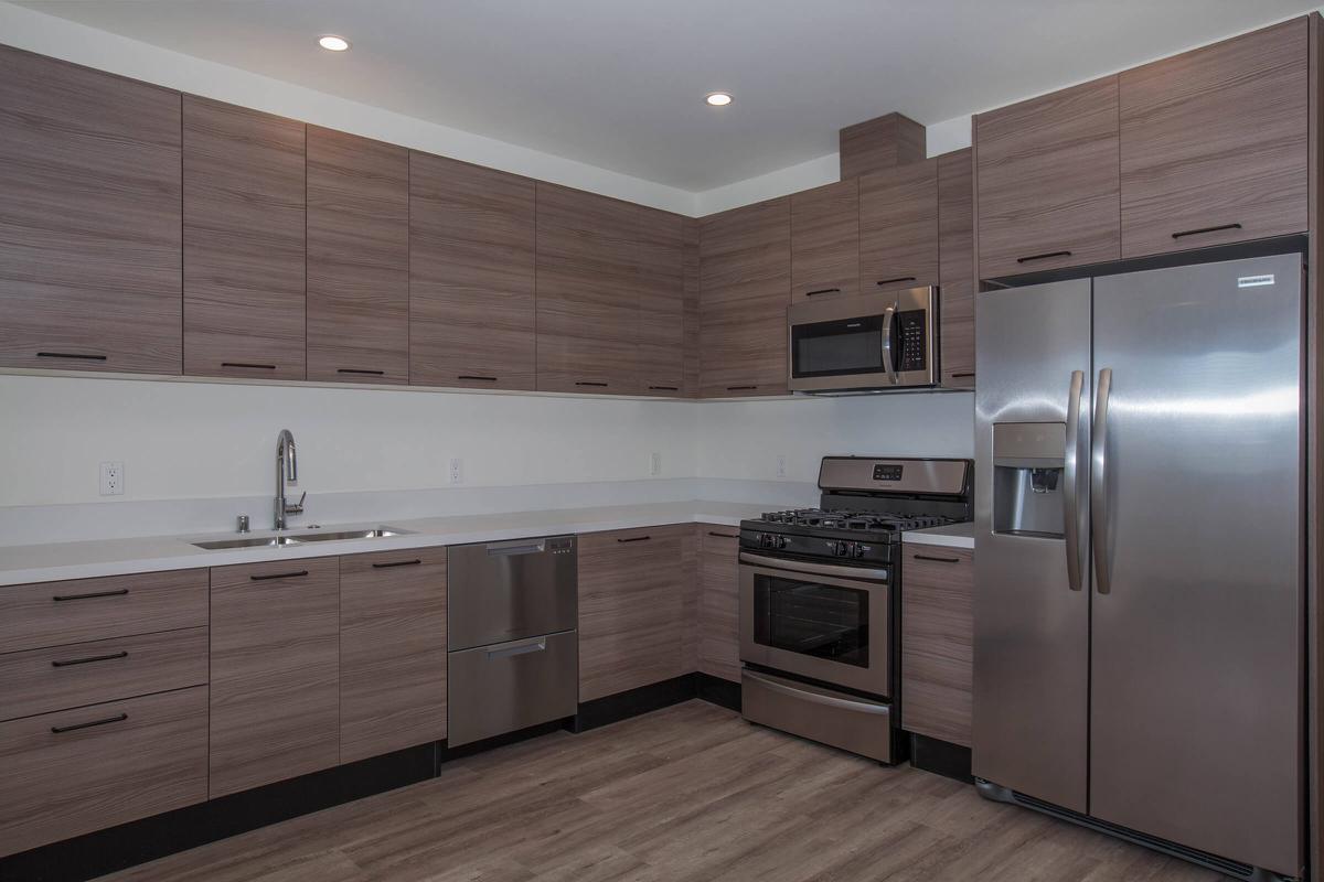 a large kitchen with stainless steel appliances and wooden cabinets