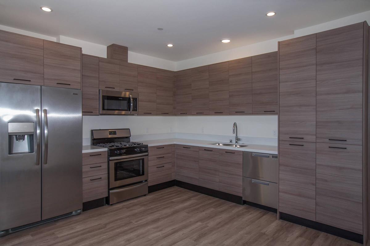 a large kitchen with stainless steel appliances and wooden cabinets