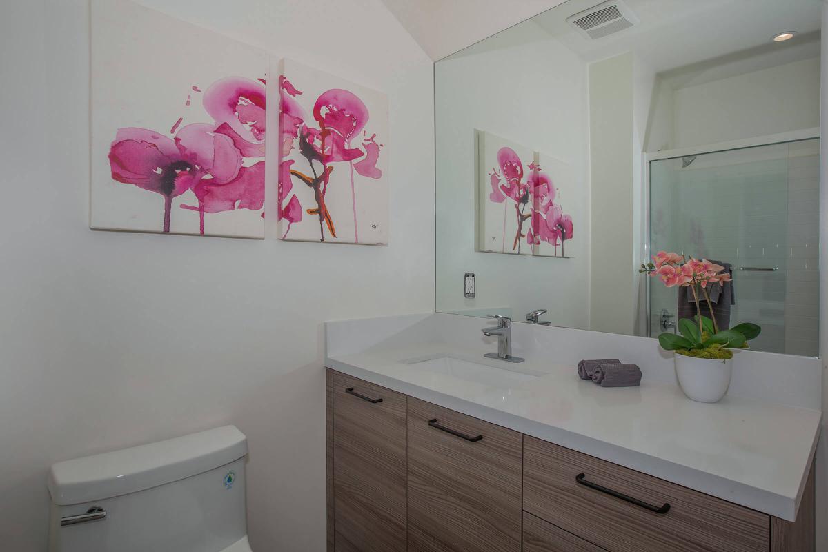 a white sink sitting under a mirror