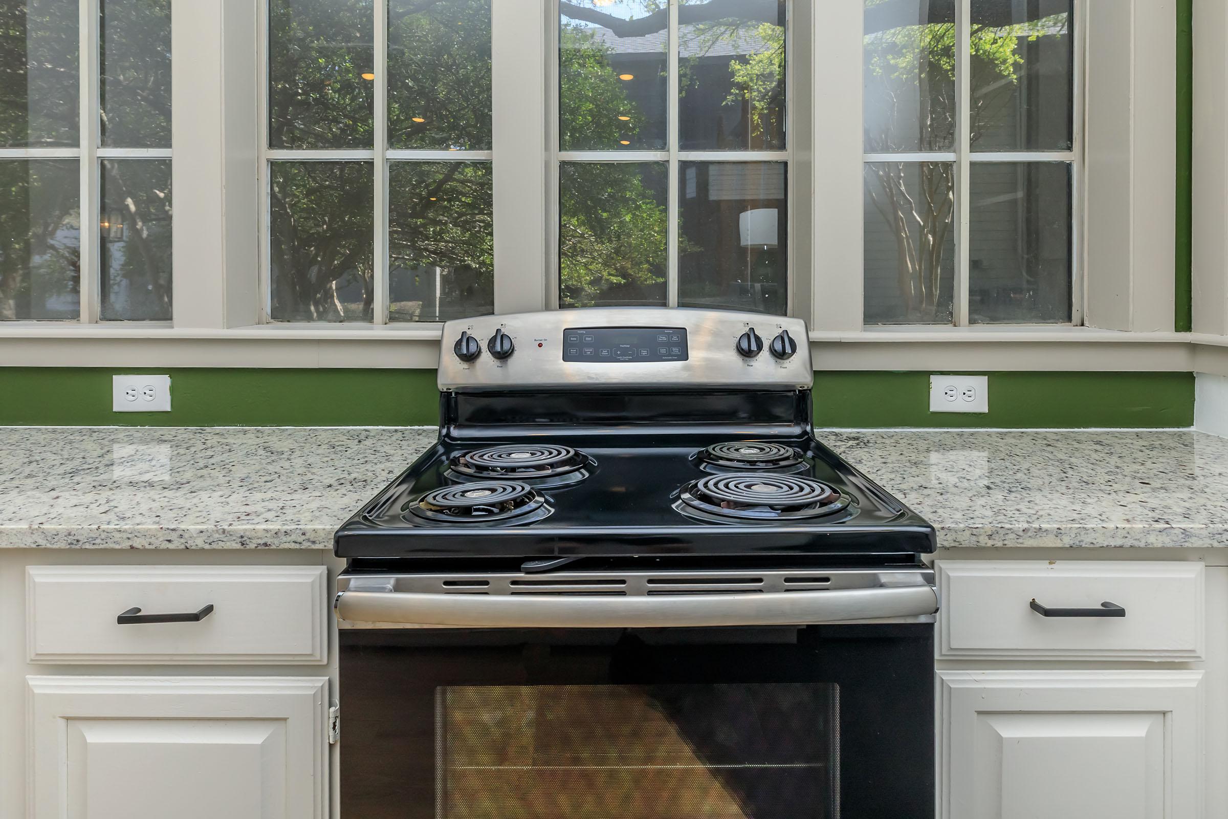 a kitchen with a stove top oven sitting next to a window