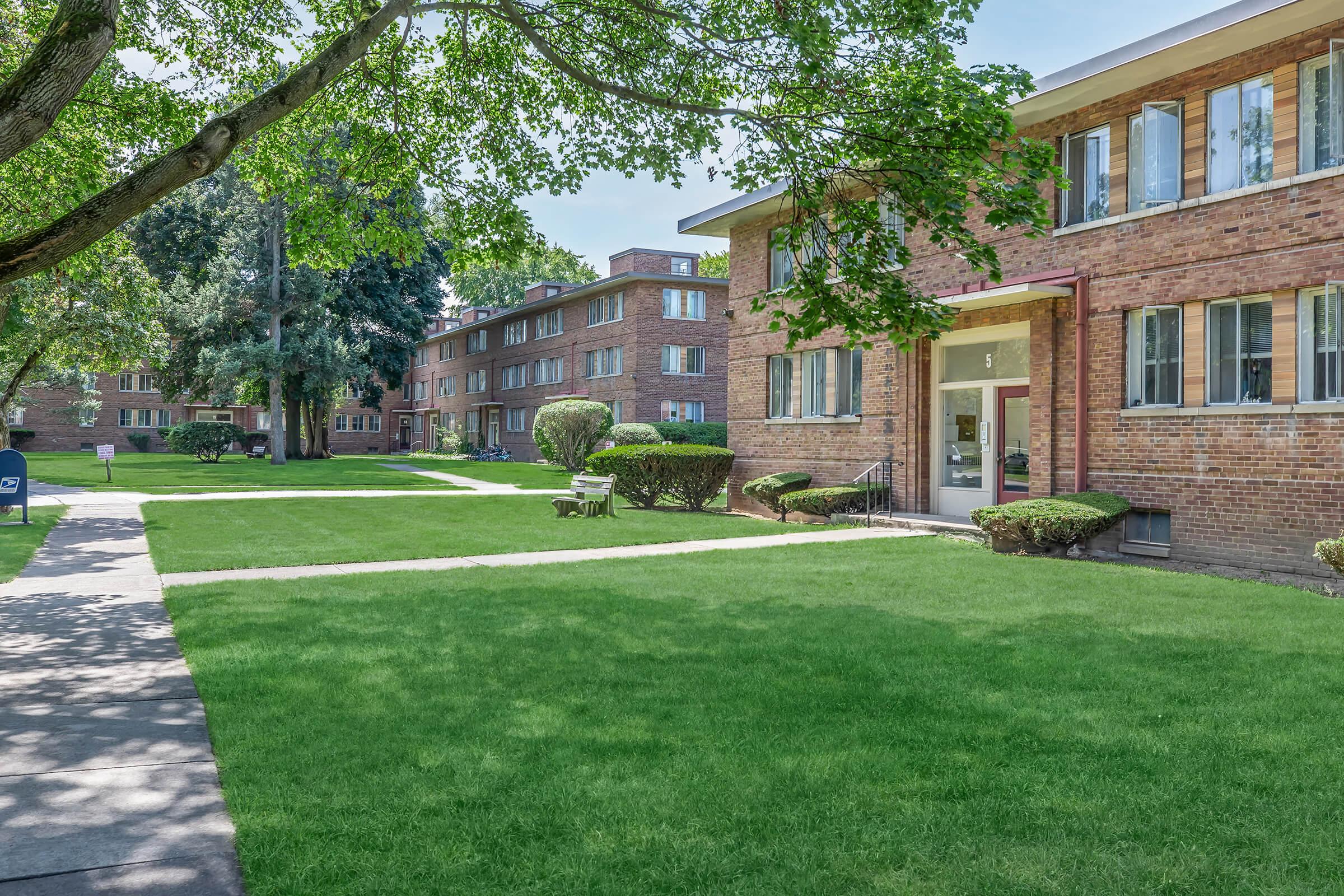 a large lawn in front of a brick building