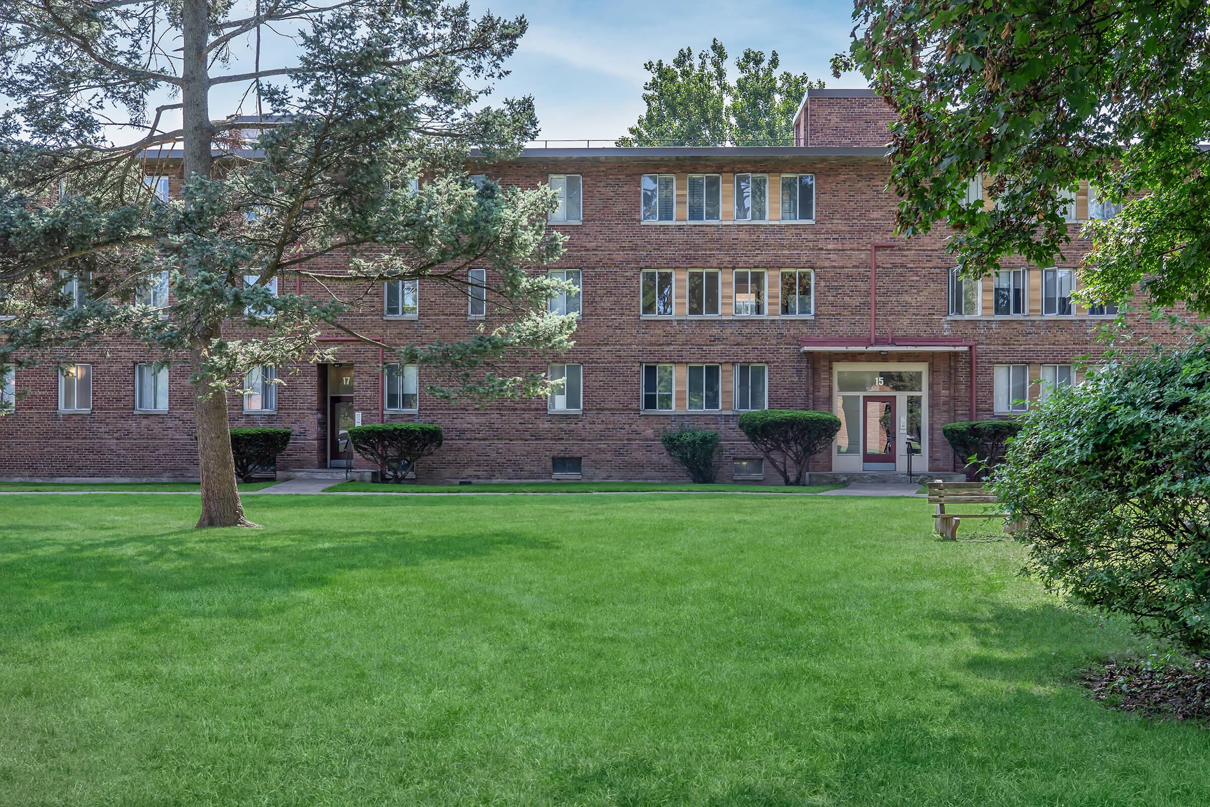 a large lawn in front of a brick building