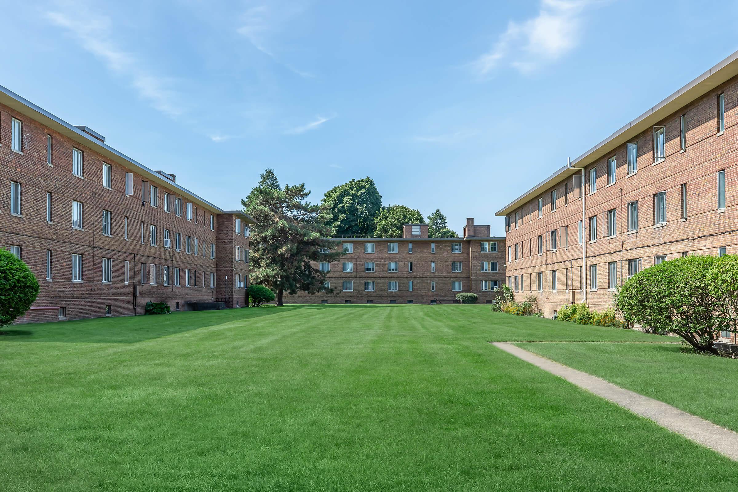 a large lawn in front of a brick building