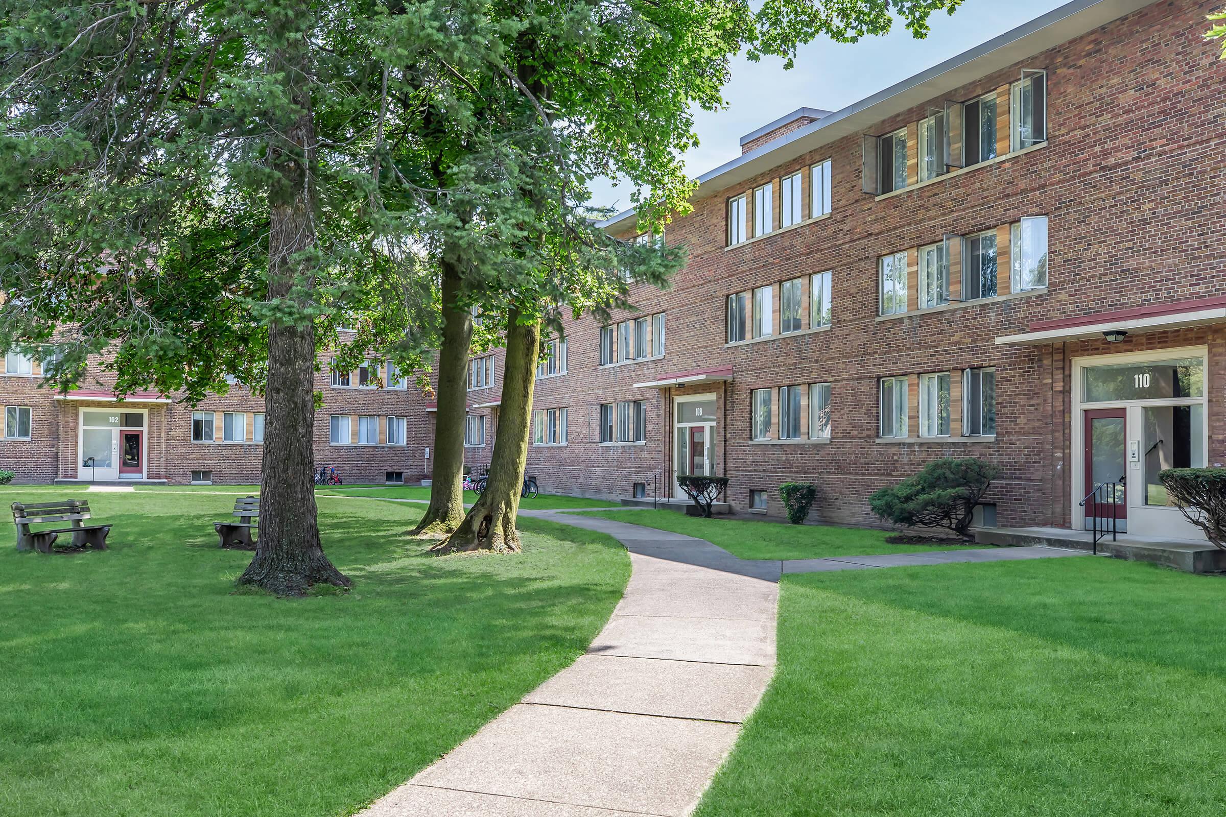 a large brick building with grass in front of a house