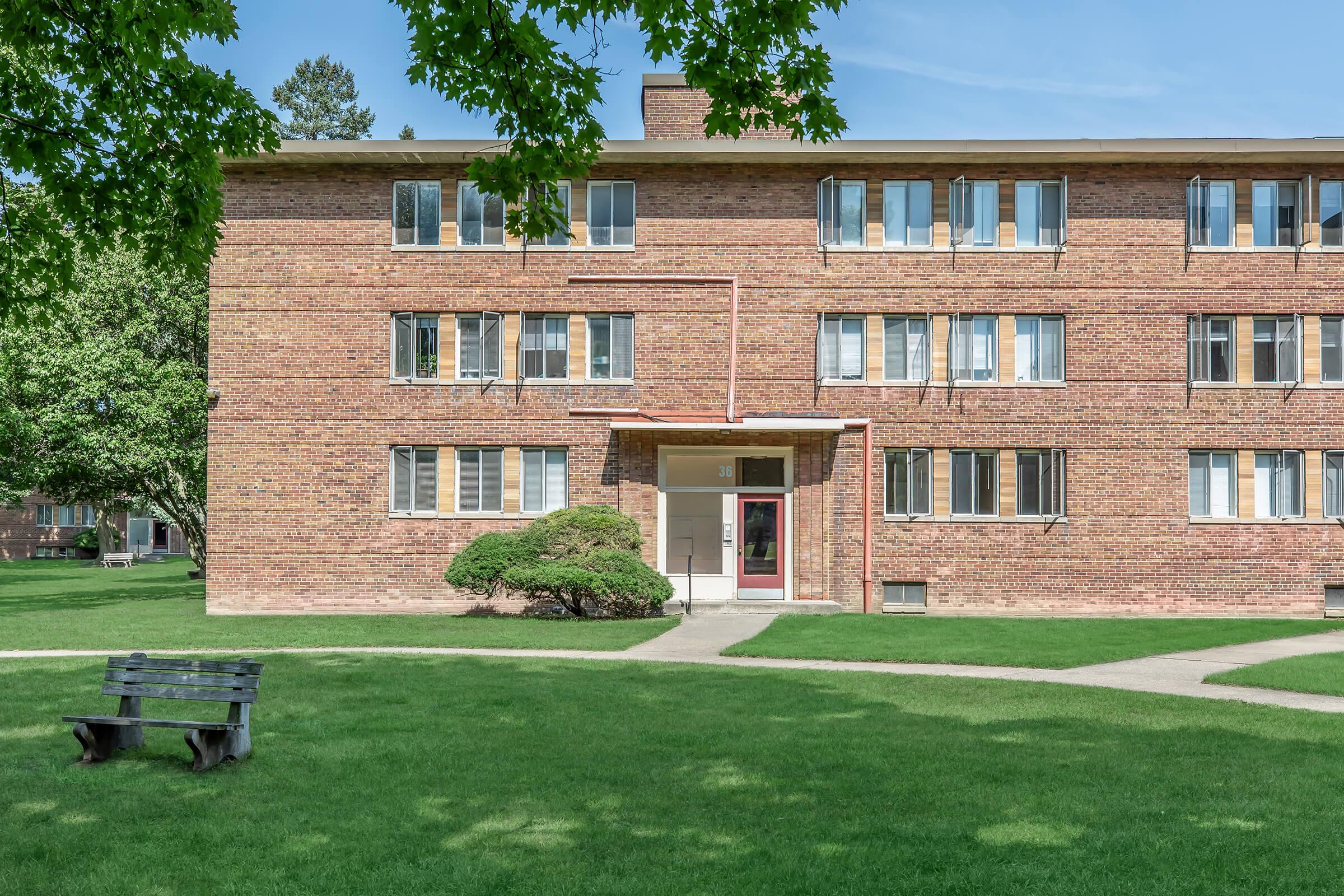 a large lawn in front of a brick building