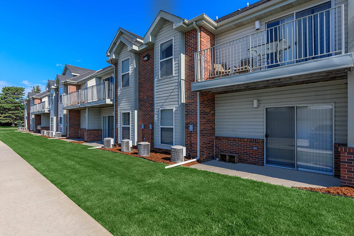 a large brick building with grass in front of a house