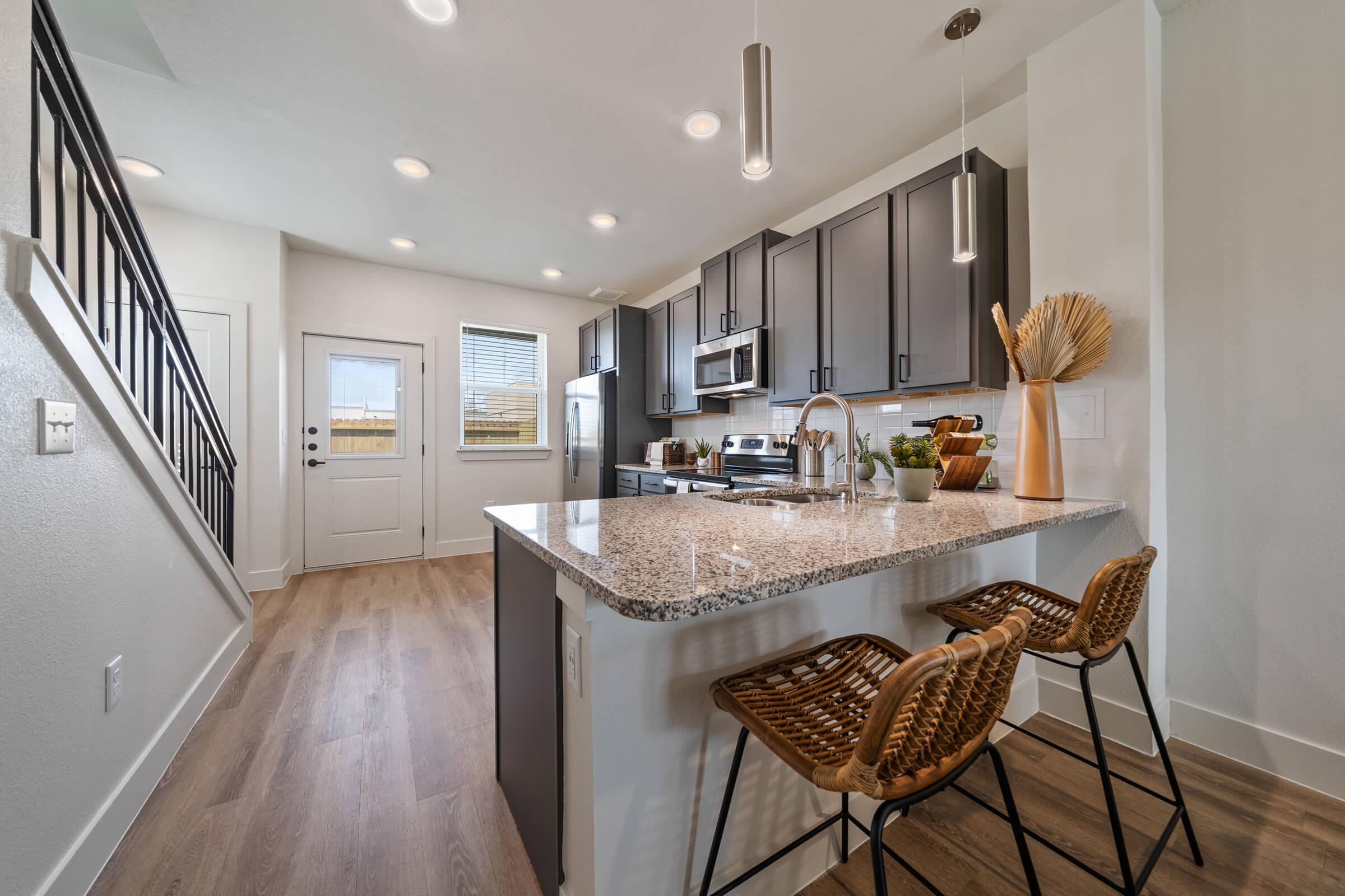 a kitchen with a sink and a chair in a room