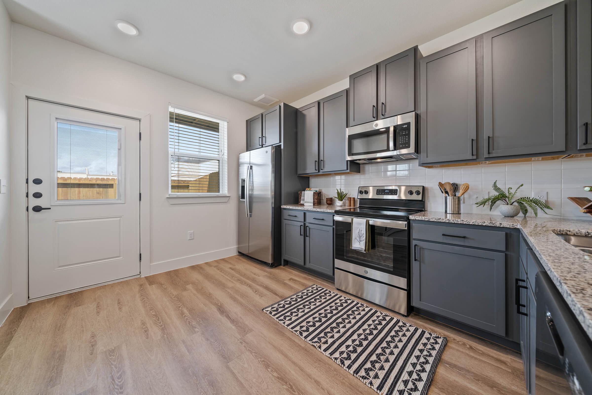 a modern kitchen with stainless steel appliances and wooden cabinets