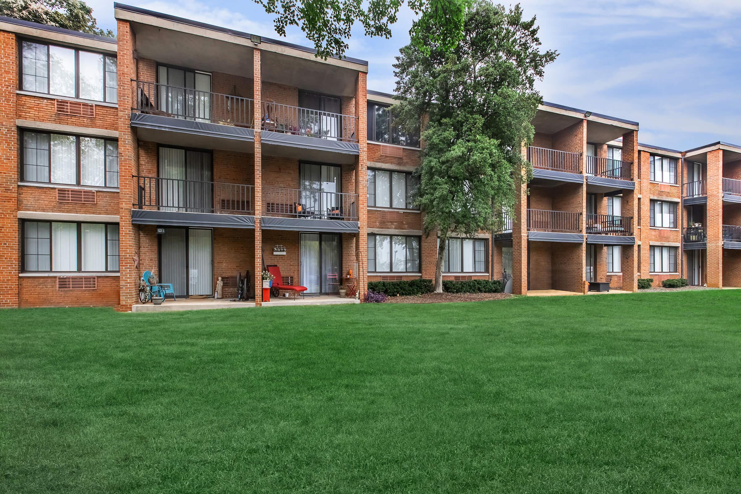 a large lawn in front of a brick building