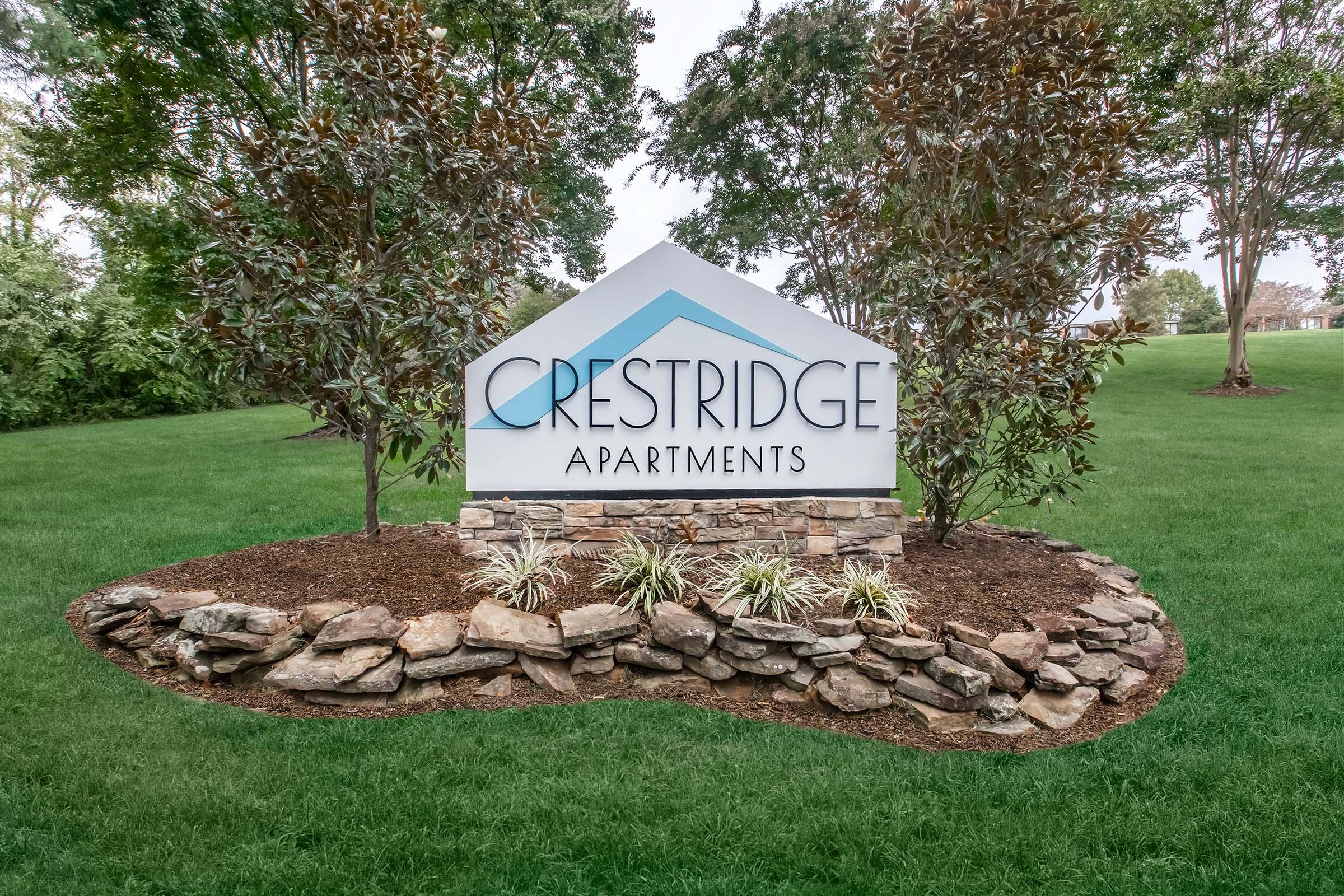 a sign in front of a large rock