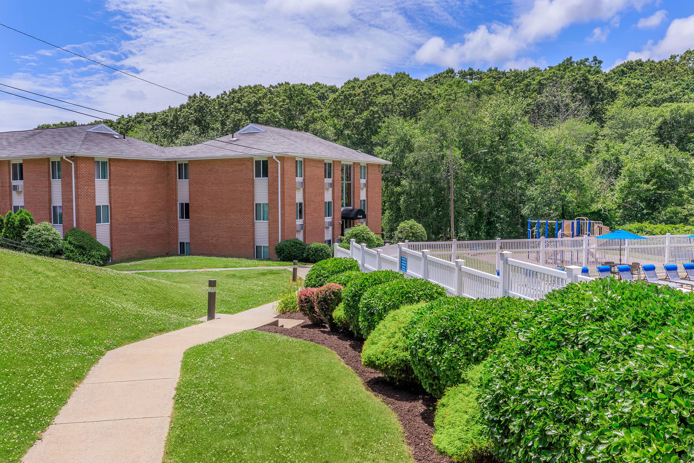 a large brick building with green grass