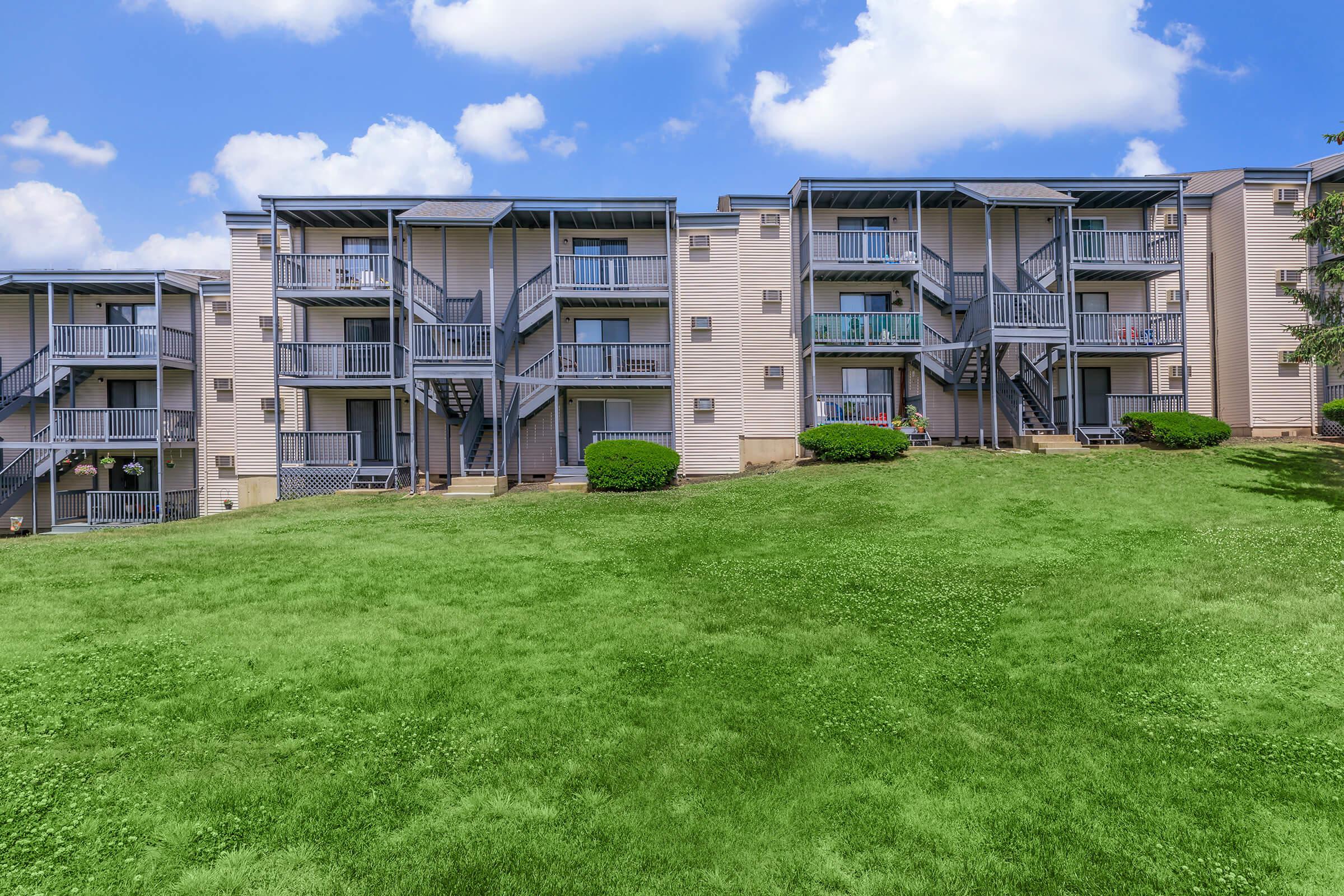 a large green field in front of a building